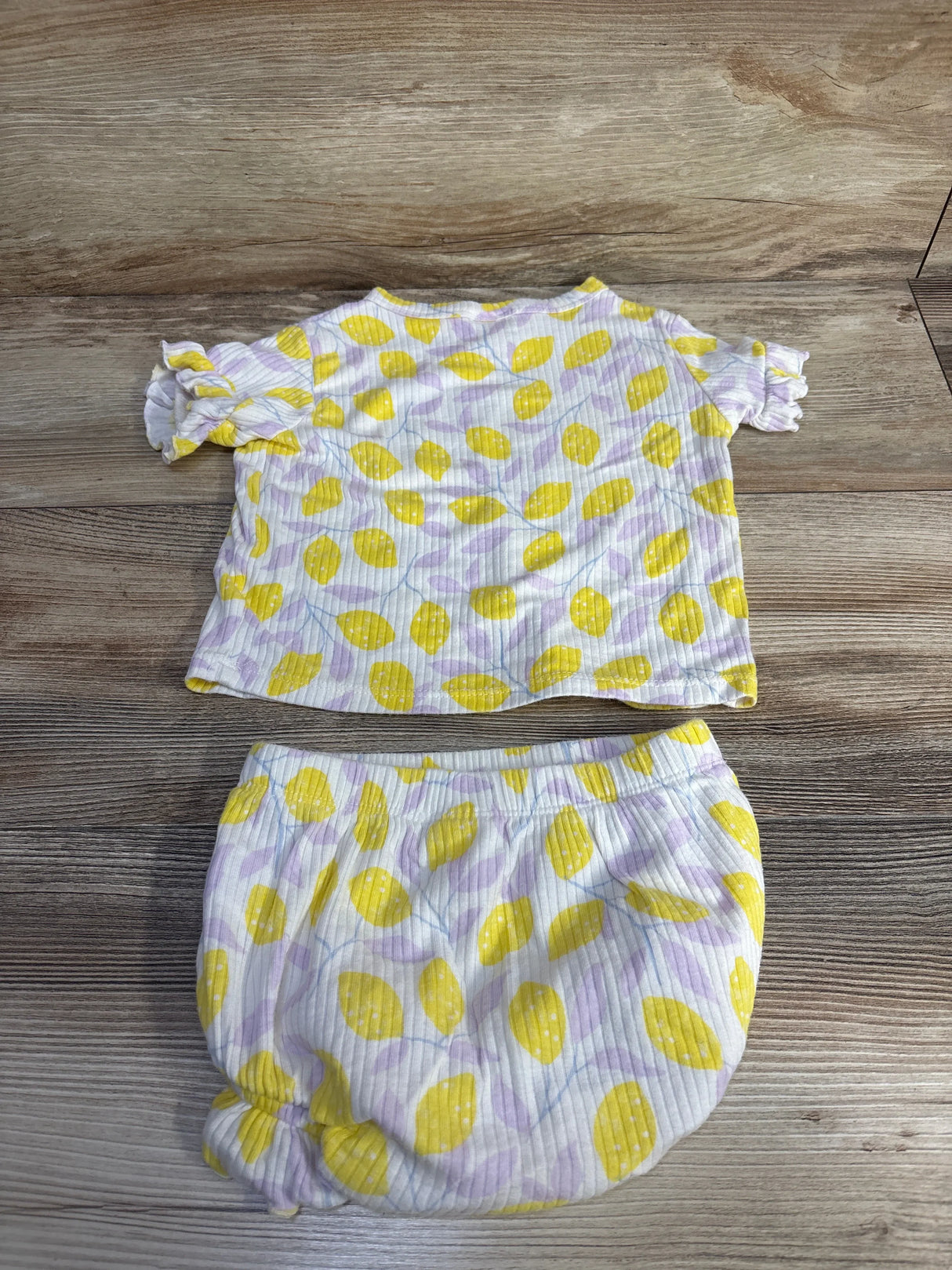 Flat lay of Cat & Jack 2-piece lemon-print ribbed shirt and bloomer set showing ruffle sleeves and elastic waist on wood background