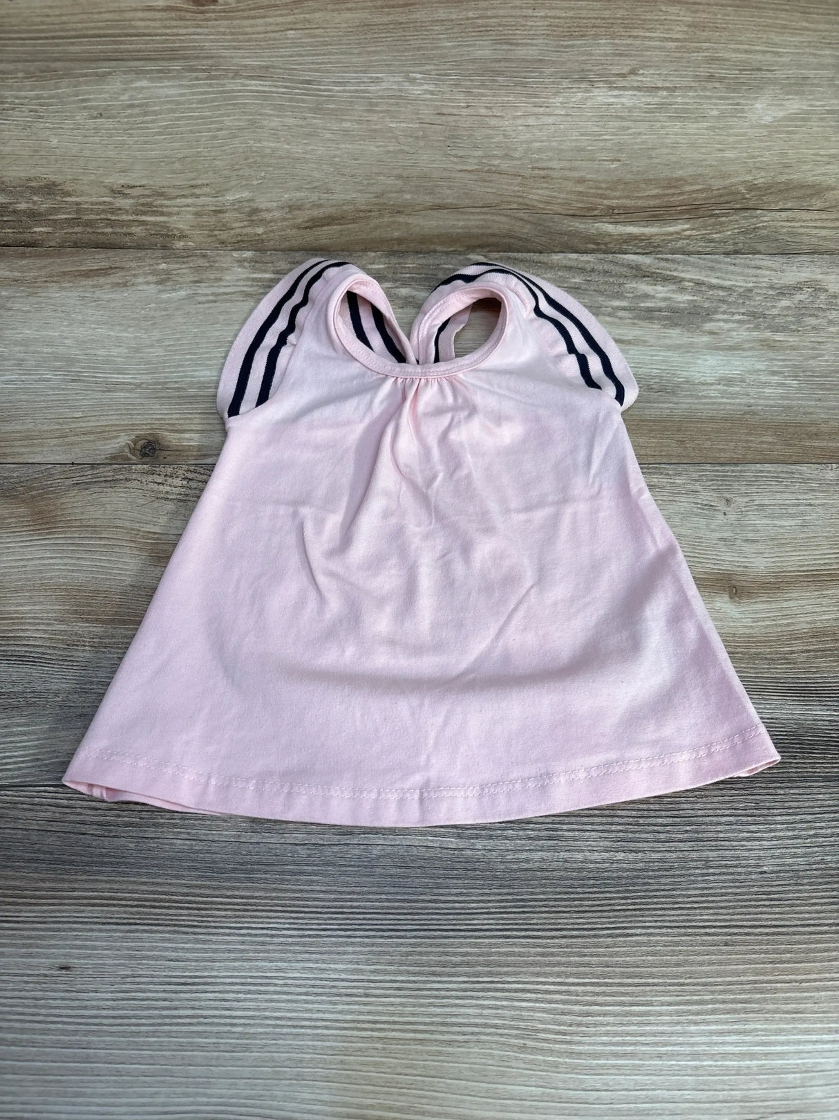 Front flat lay of pink Milon sleeveless toddler top (12m) showing navy double striped cap sleeves on wood background