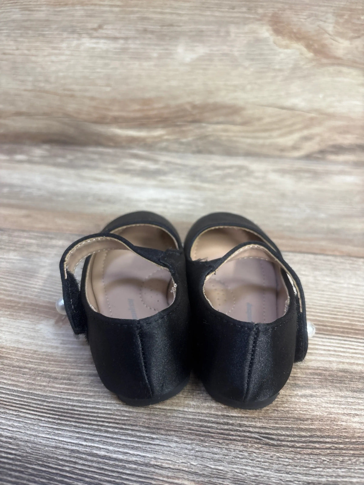 Front view of FunkyMonkey Mary Jane ballet flats showcasing black round toes and Mary Jane straps on a wood-grain surface