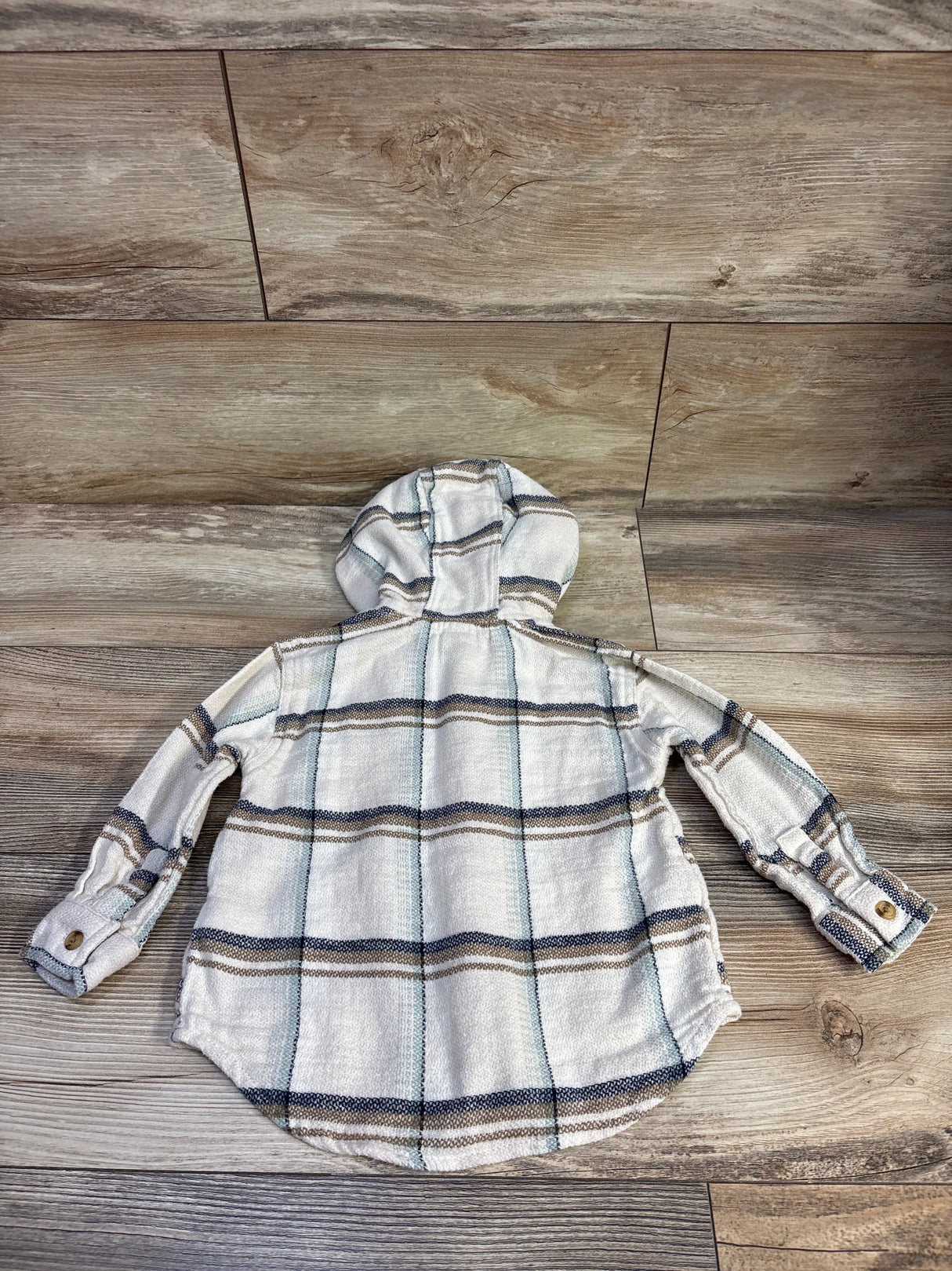 Back flat lay of Old Navy hooded flannel shirt size 2T showing beige plaid, hood, and button cuffs on wood floor