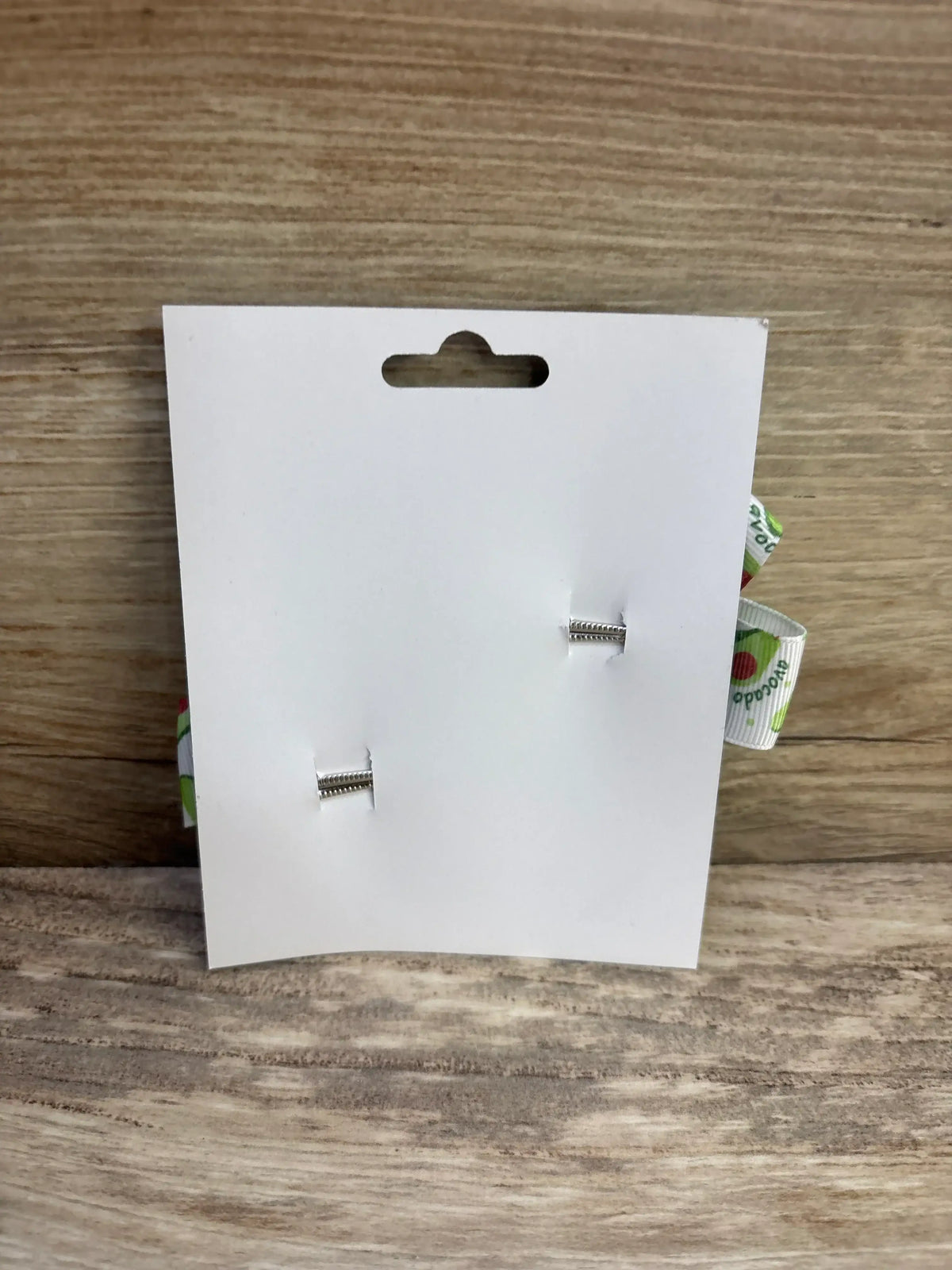Front view of 2-pack fanned avocado-print hair bows on white display card showing silver metal clips on wood background