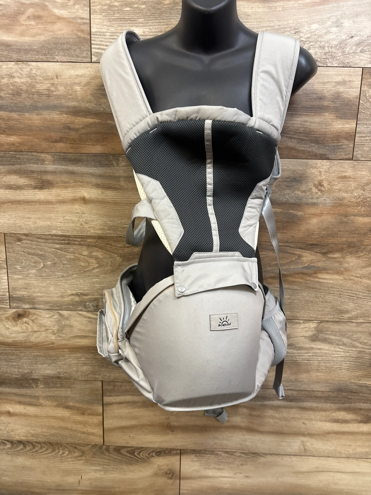 Grey Momtory 6-in-1 baby carrier for newborns to toddlers on a black mannequin.