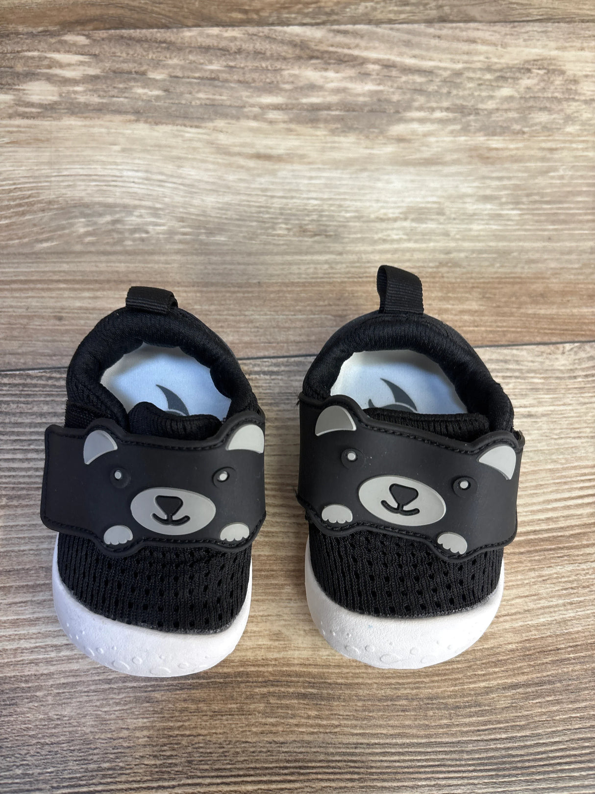 Top view of FEETCITY mesh toddler shoes size 4/5C with bear-face Velcro straps and white soft soles on wood floor