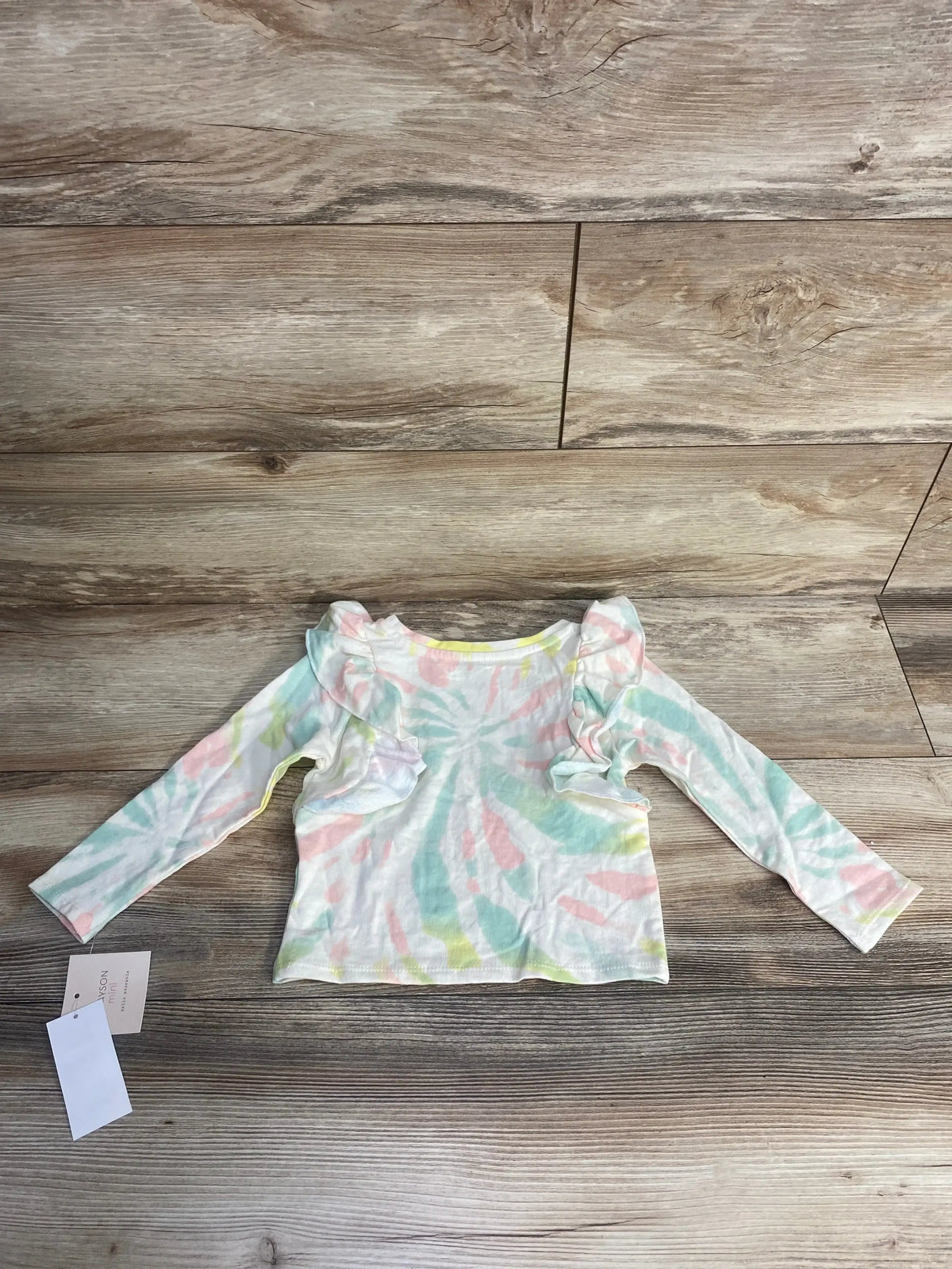 Toddler long sleeve ruffle shirt with pastel tie-dye pattern on wooden floor