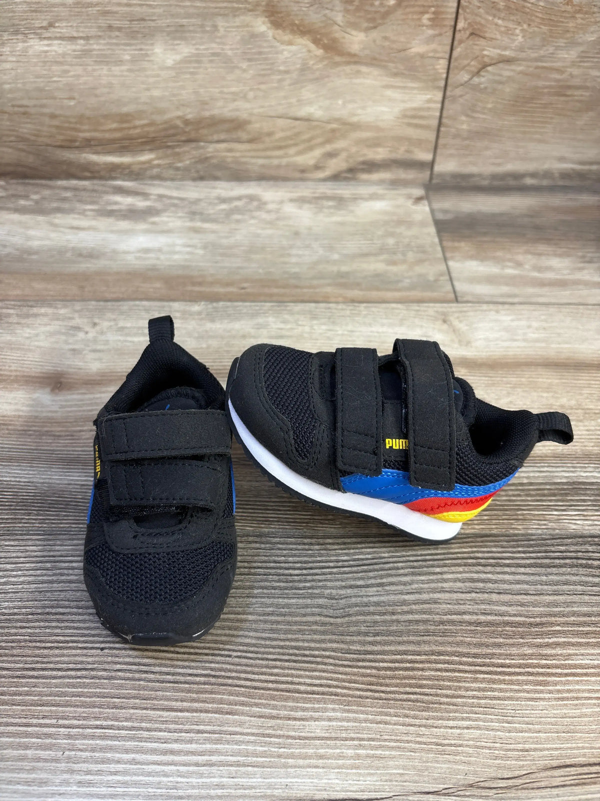 Top and side views of black Puma R78 double strap sneakers in size 3C showcasing cushioned soles on a wood look floor