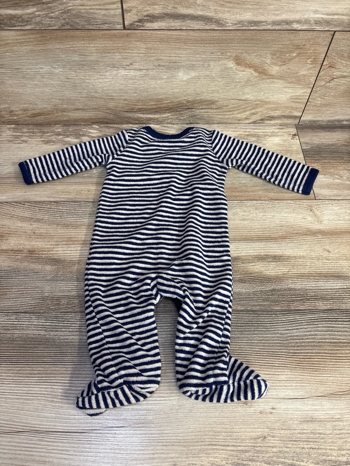 Navy and white striped baby sleeper laid flat on wood floor