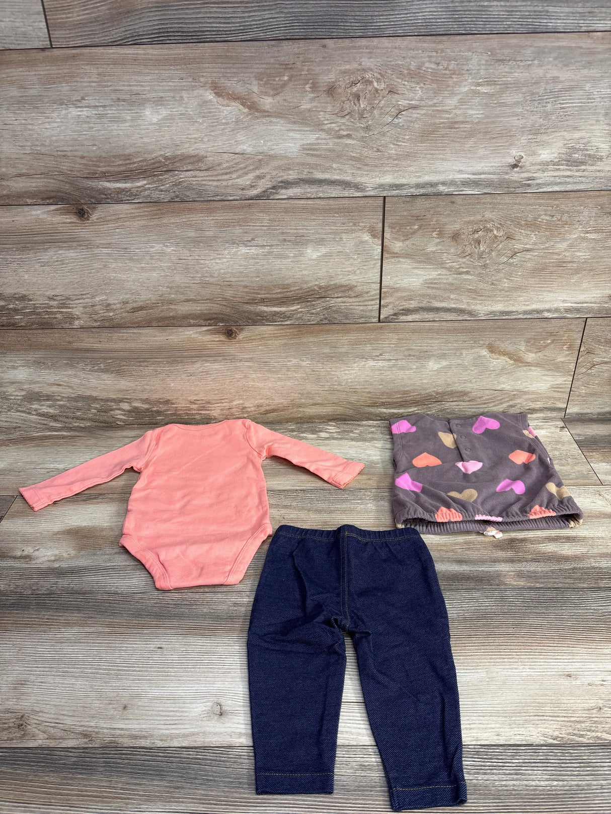 Baby girl outfit set with pink long sleeve bodysuit, dark leggings, and heart print skirt