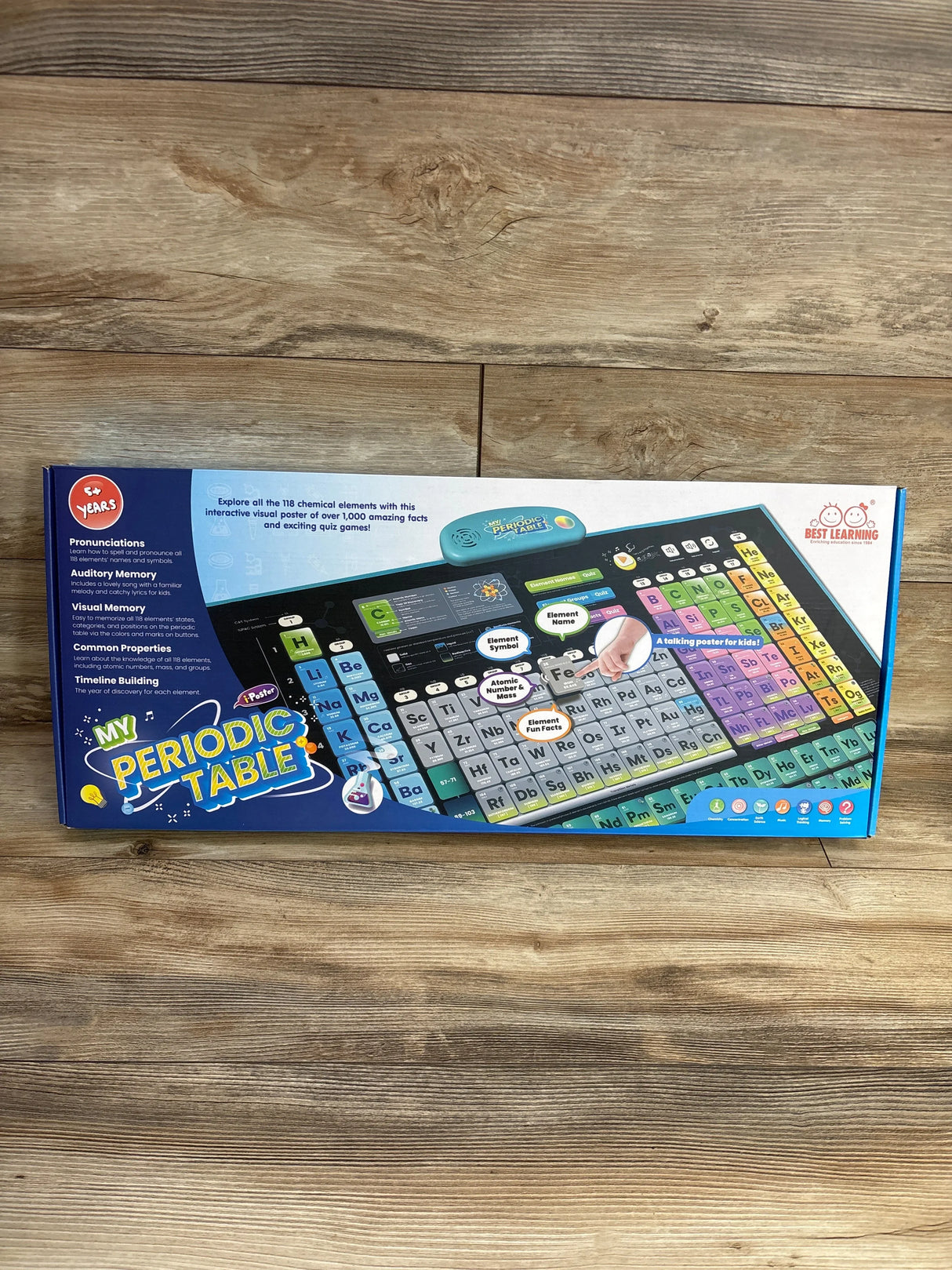 Interactive kids' periodic table learning toy in retail packaging on wood background