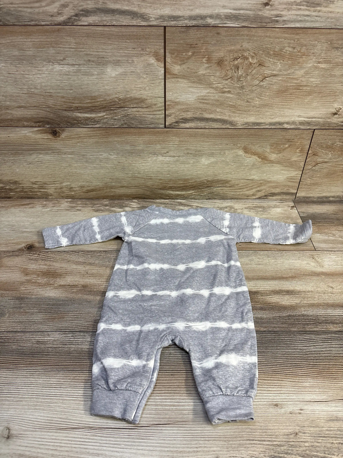 Top view of Geber striped gray coverall in size 0 to 3 months showcasing white horizontal stripes on a wood floor