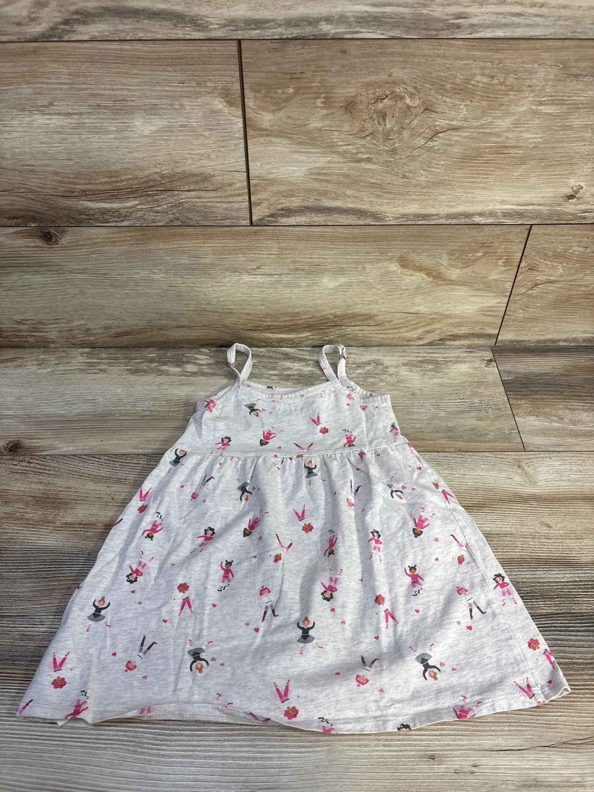 Front flat lay of girls’ Old Navy oatmeal dress size 3T showcasing thin straps, gathered skirt, and pink ballerina print on wood floor