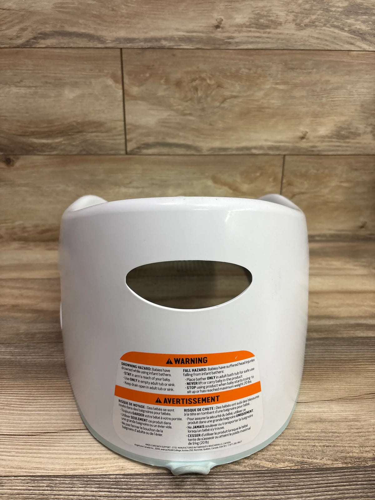 Close-up of warning labels on the back of a white Me 'n Mommy To Be baby bath support.