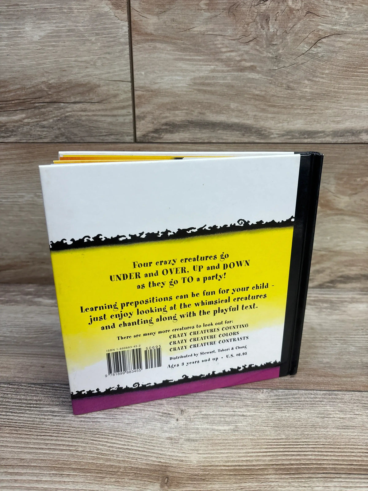 Back view of Crazy Creature Capers hardcover book showing yellow and purple cover text about going under over up and down