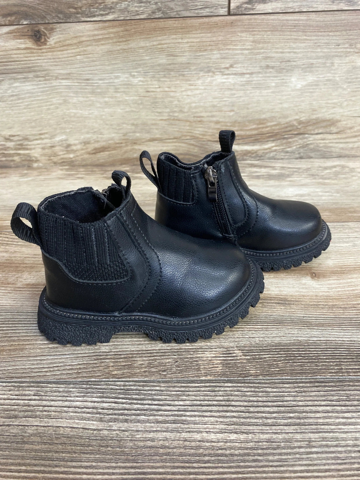 Black toddler ankle boots with side zipper on wood floor, gently used kids footwear