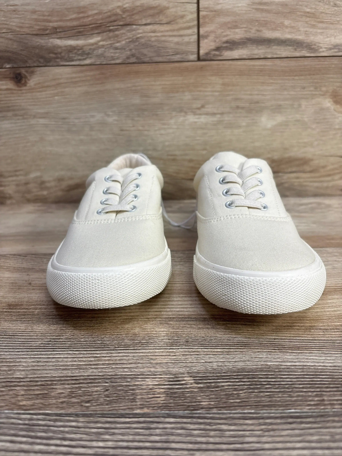 Front view of Cat & Jack Tyler kids slip-on sneakers showcasing off-white canvas upper and textured white rubber sole on wood floor