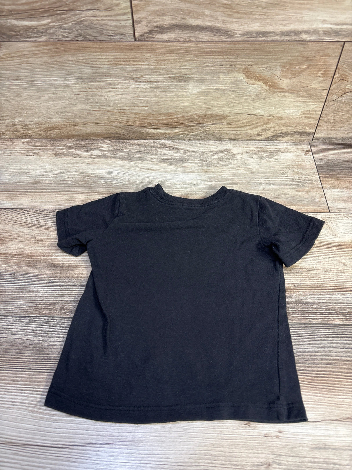 Back view of toddler black Ramones T-shirt showing plain back on wood floor