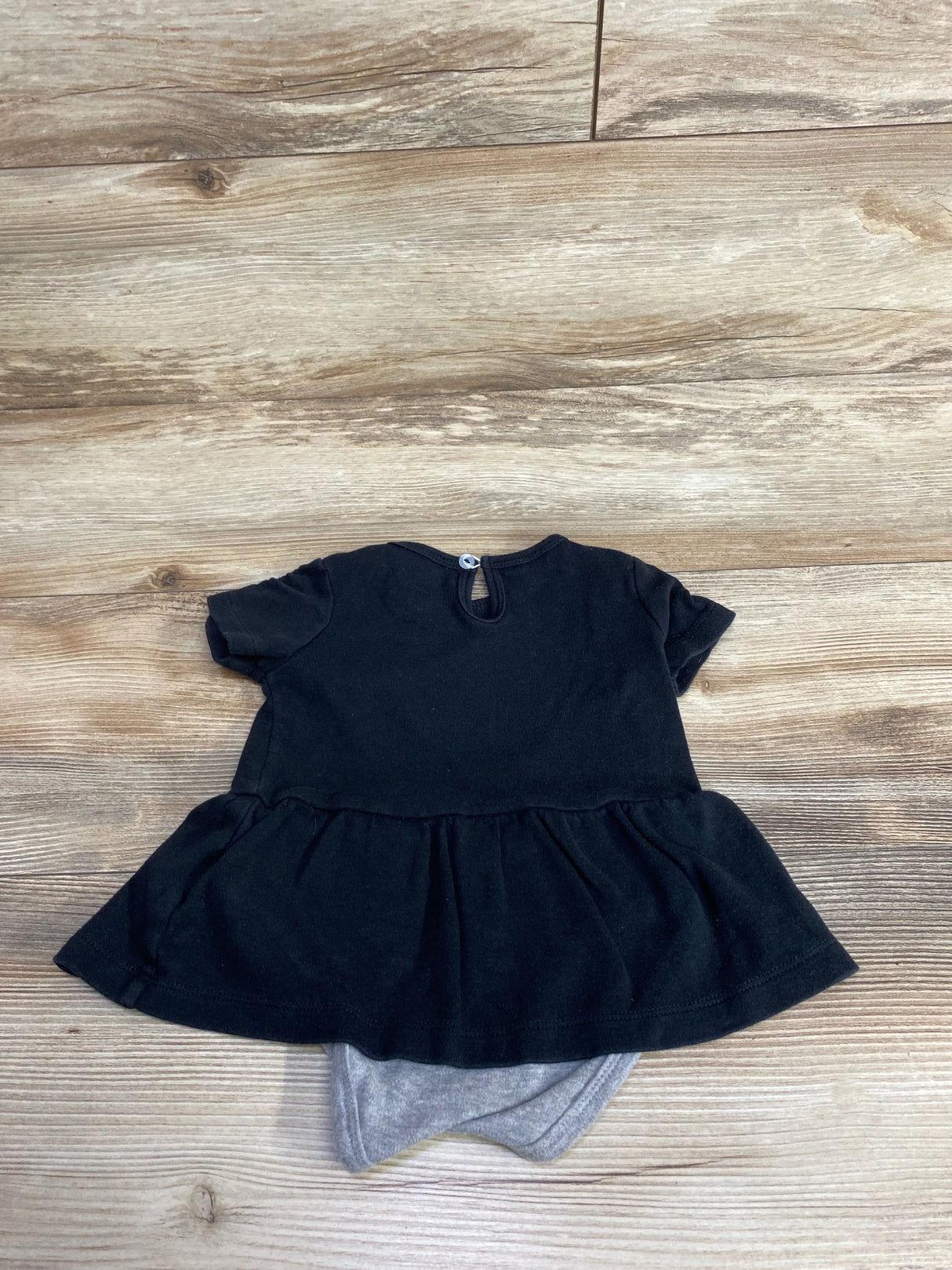 Black short sleeve baby dress with grey bloomers on wooden floor