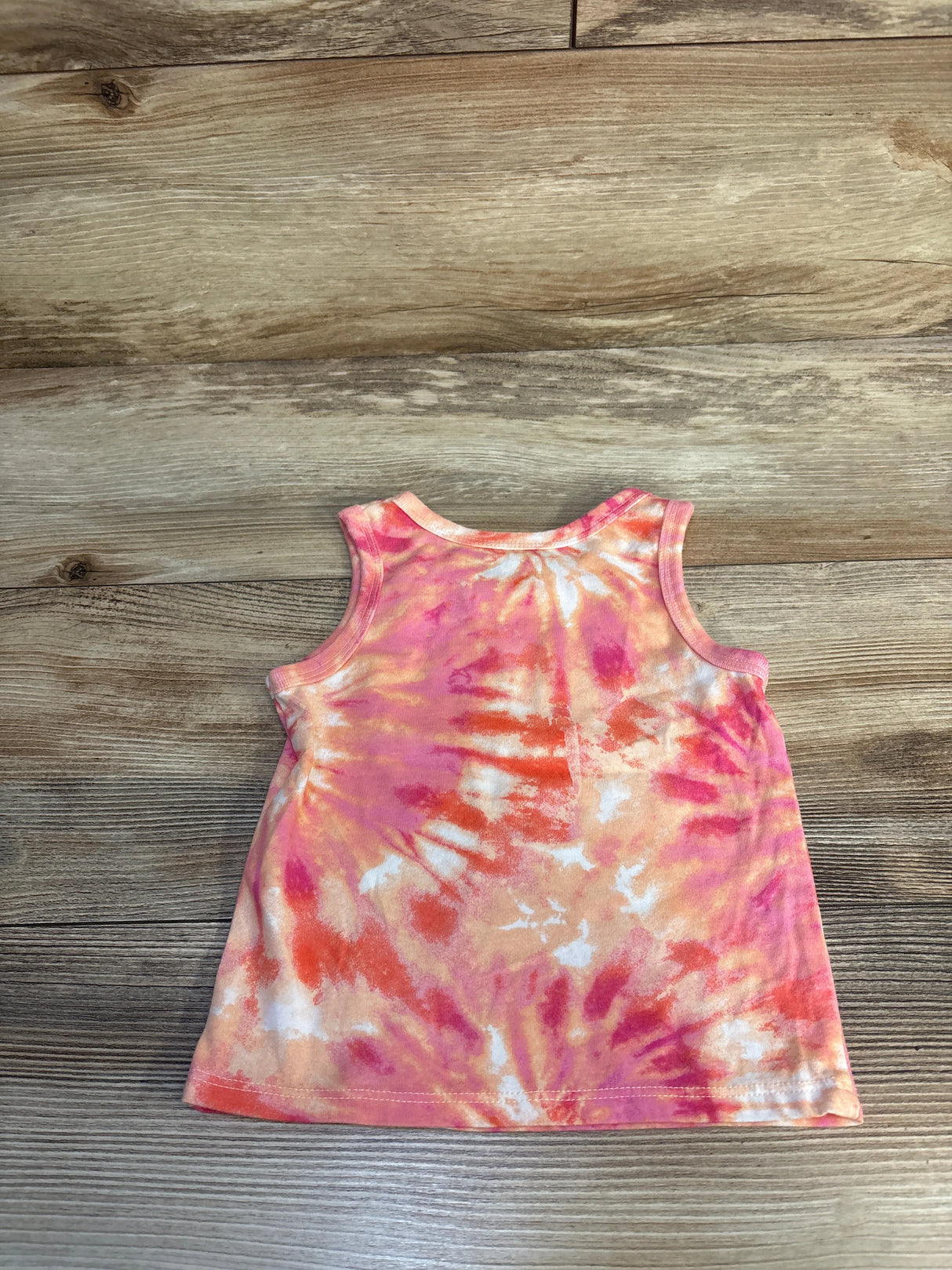 Pink and orange tie dye toddler tank top on wood background