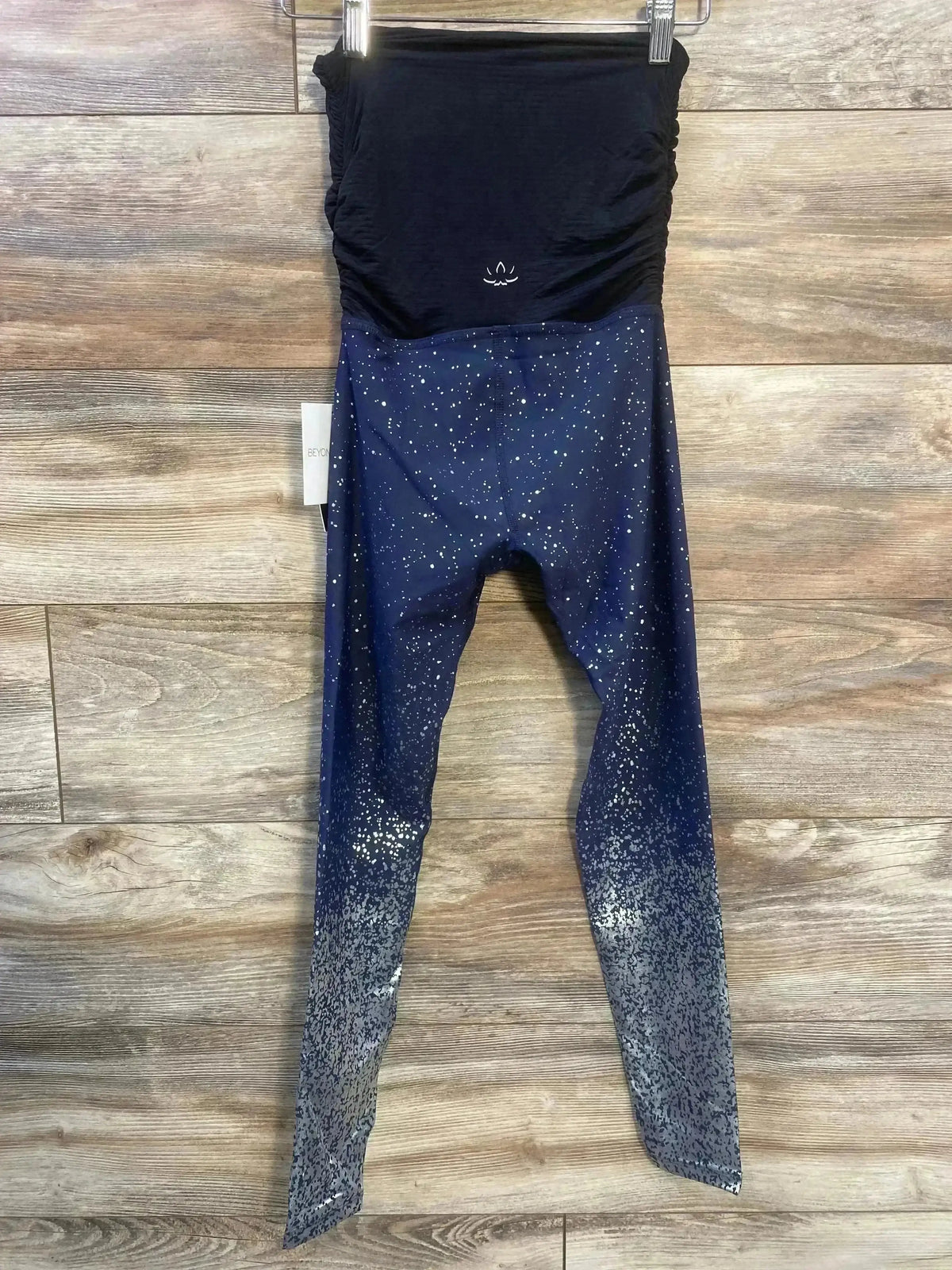 Front view of Beyond The Bump maternity full panel leggings in blue ombre with metallic dot print on wood plank floor