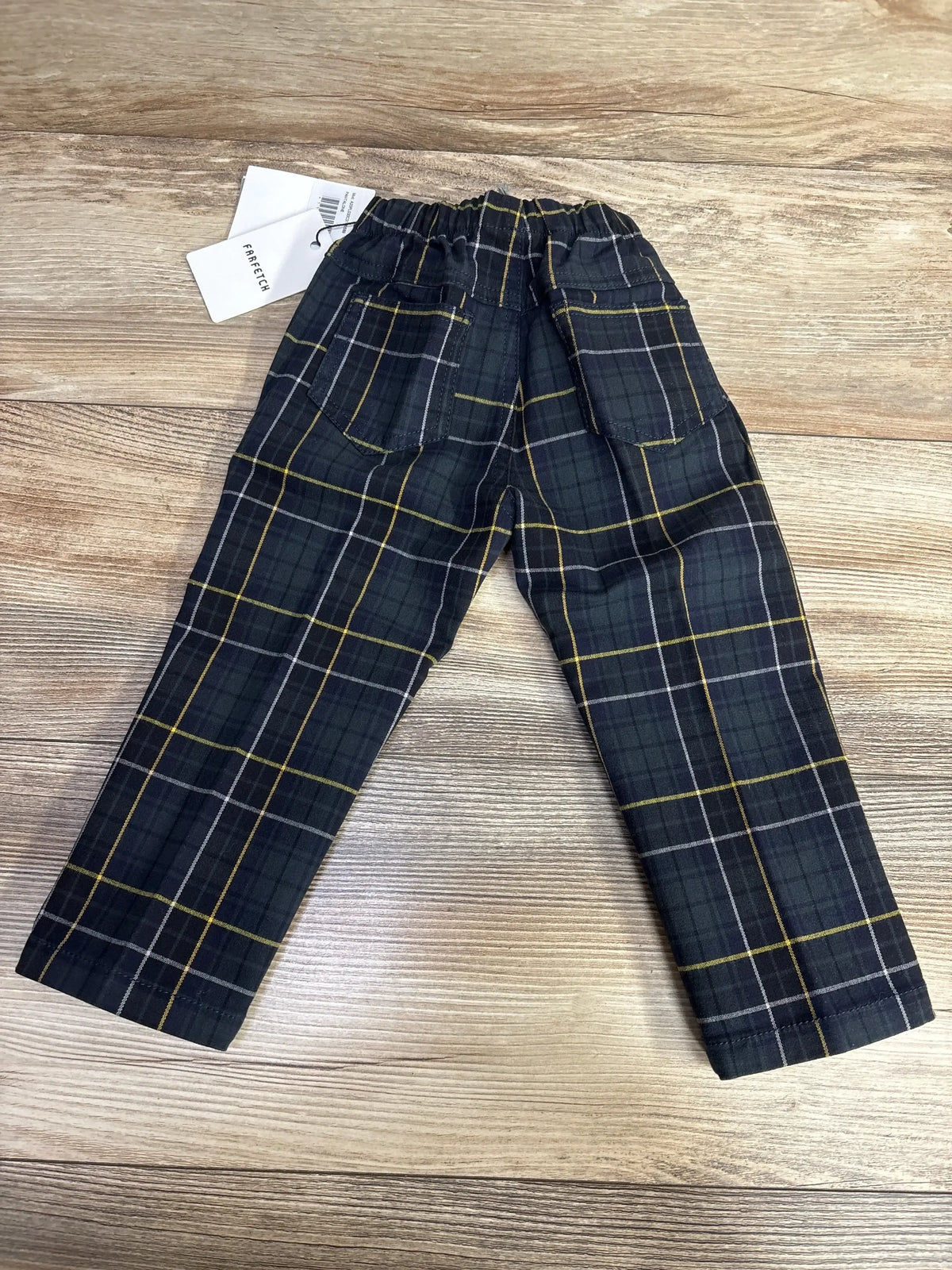 Front view of navy Il Gufo checkered trousers showcasing tartan pattern, elasticated waistband, and diagonal pockets on a wood background