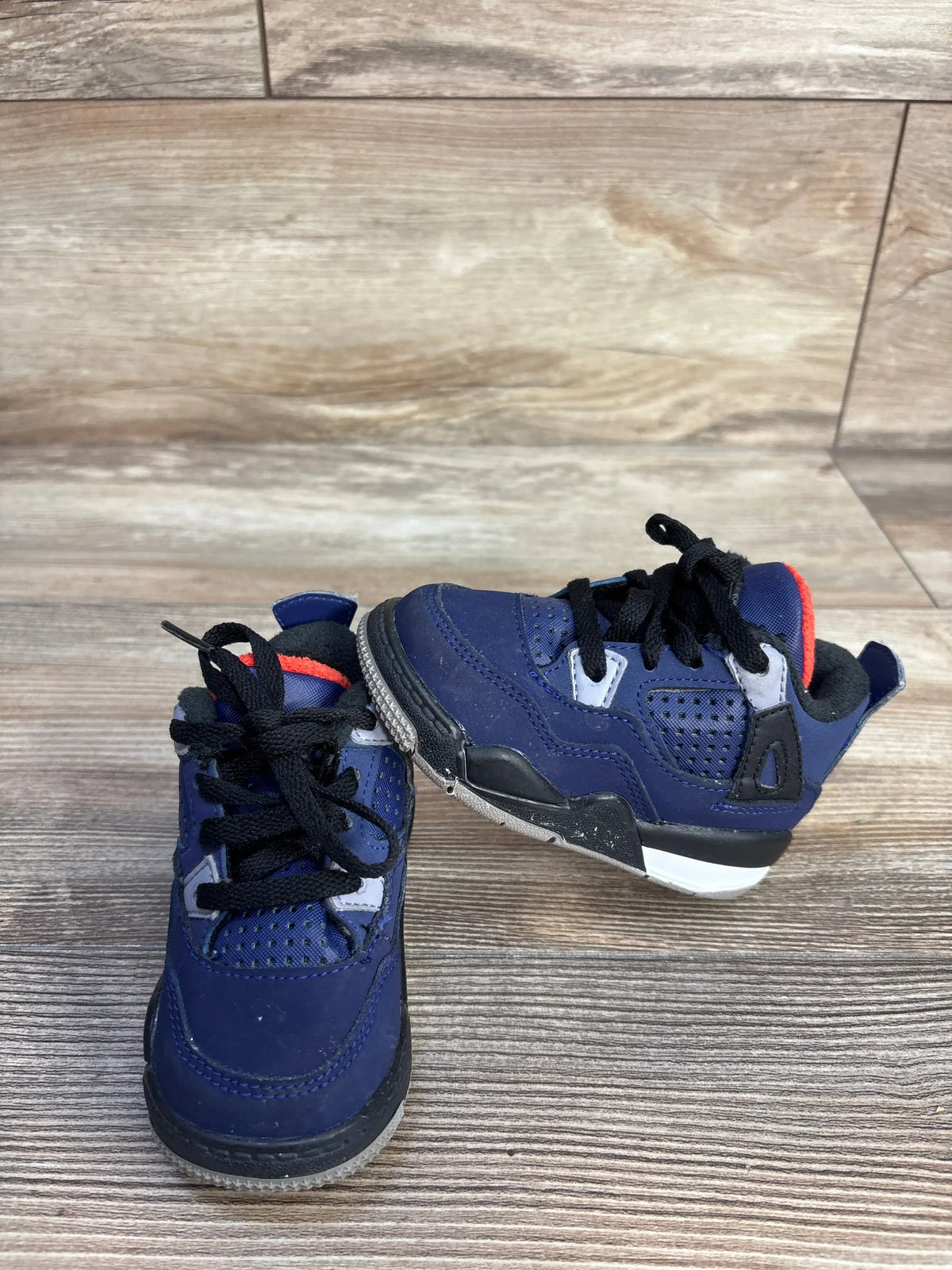 Top and side view of Air Jordan 4 Retro Winter TD toddler sneakers in Loyal Blue with functional lacing on a wood-look floor