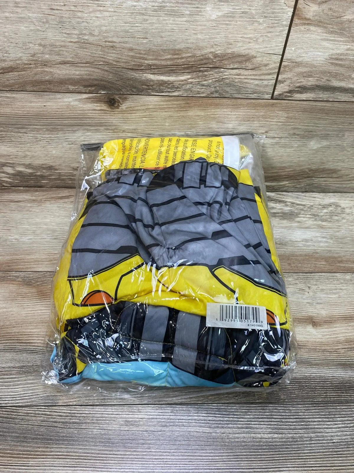 Packaged Transformers Bumblebee costume in yellow, gray, and black with printed armor design on a wood floor