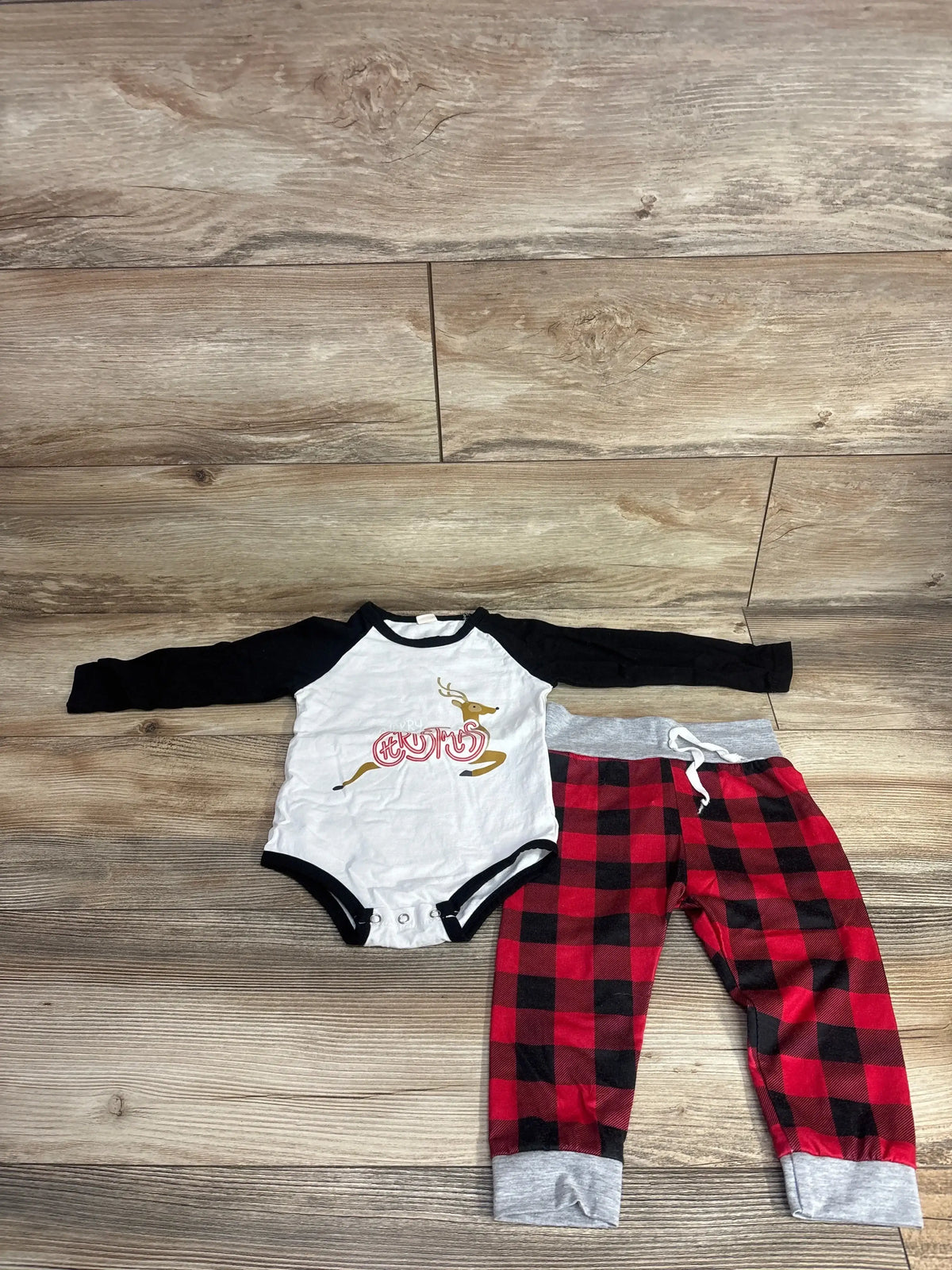 Baby Christmas outfit with reindeer graphic onesie and red plaid pants, perfect for holiday photos or cozy wear.