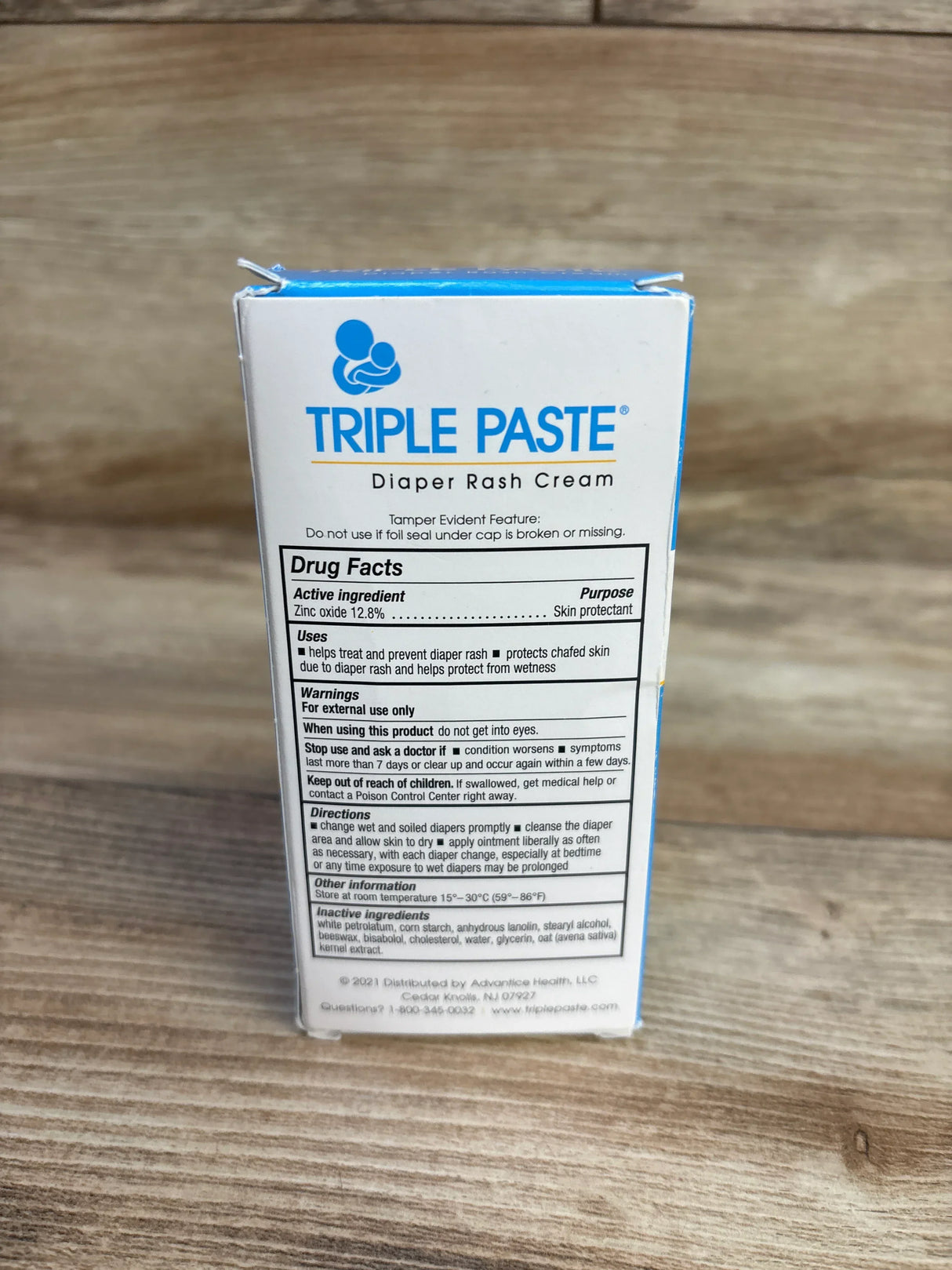 Back view of Triple Paste diaper rash cream 2 oz box showing brand logo and drug facts panel on a wooden surface