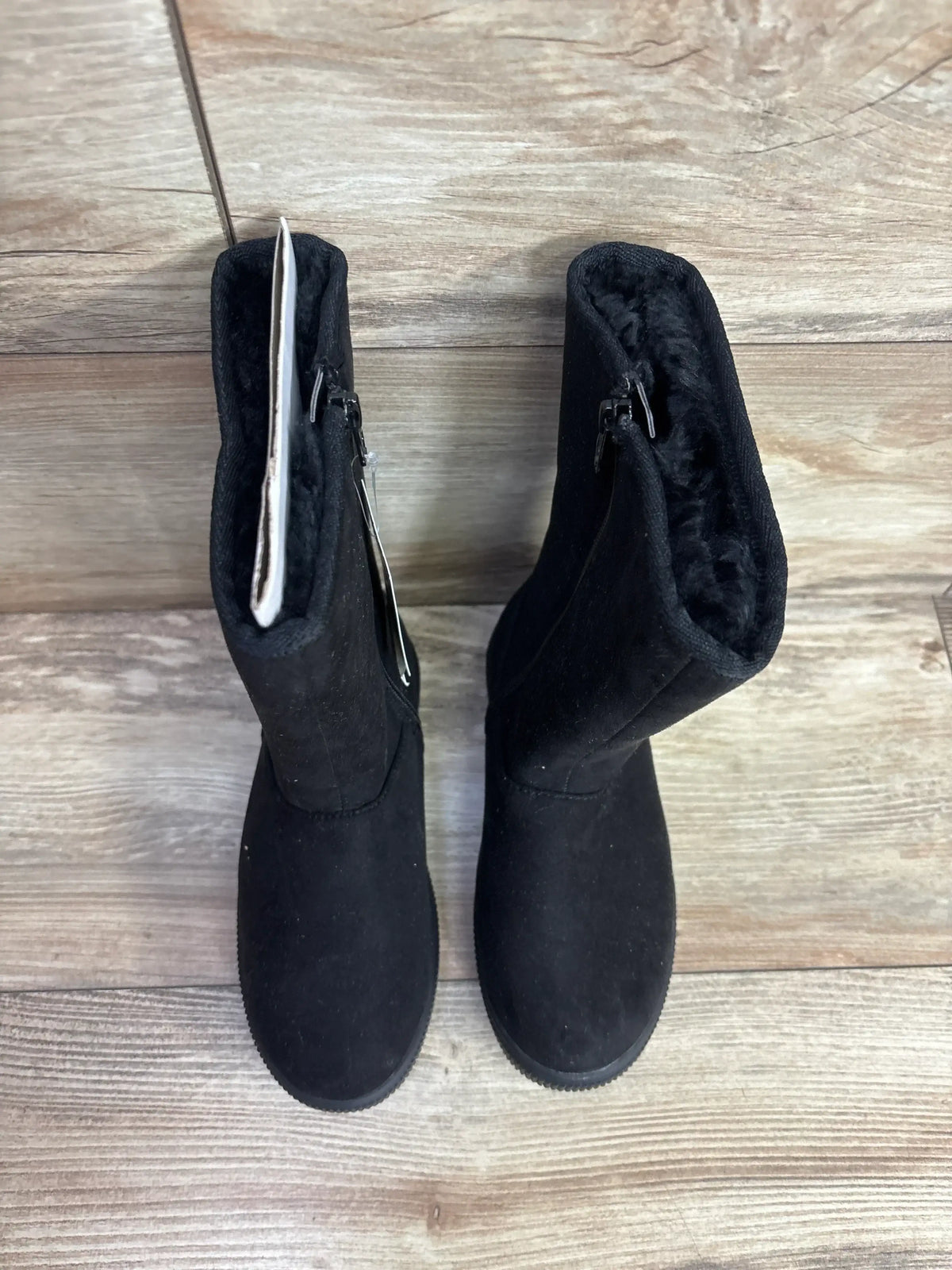 Black kids' winter boots with zippers, faux fur lining, on wood floor