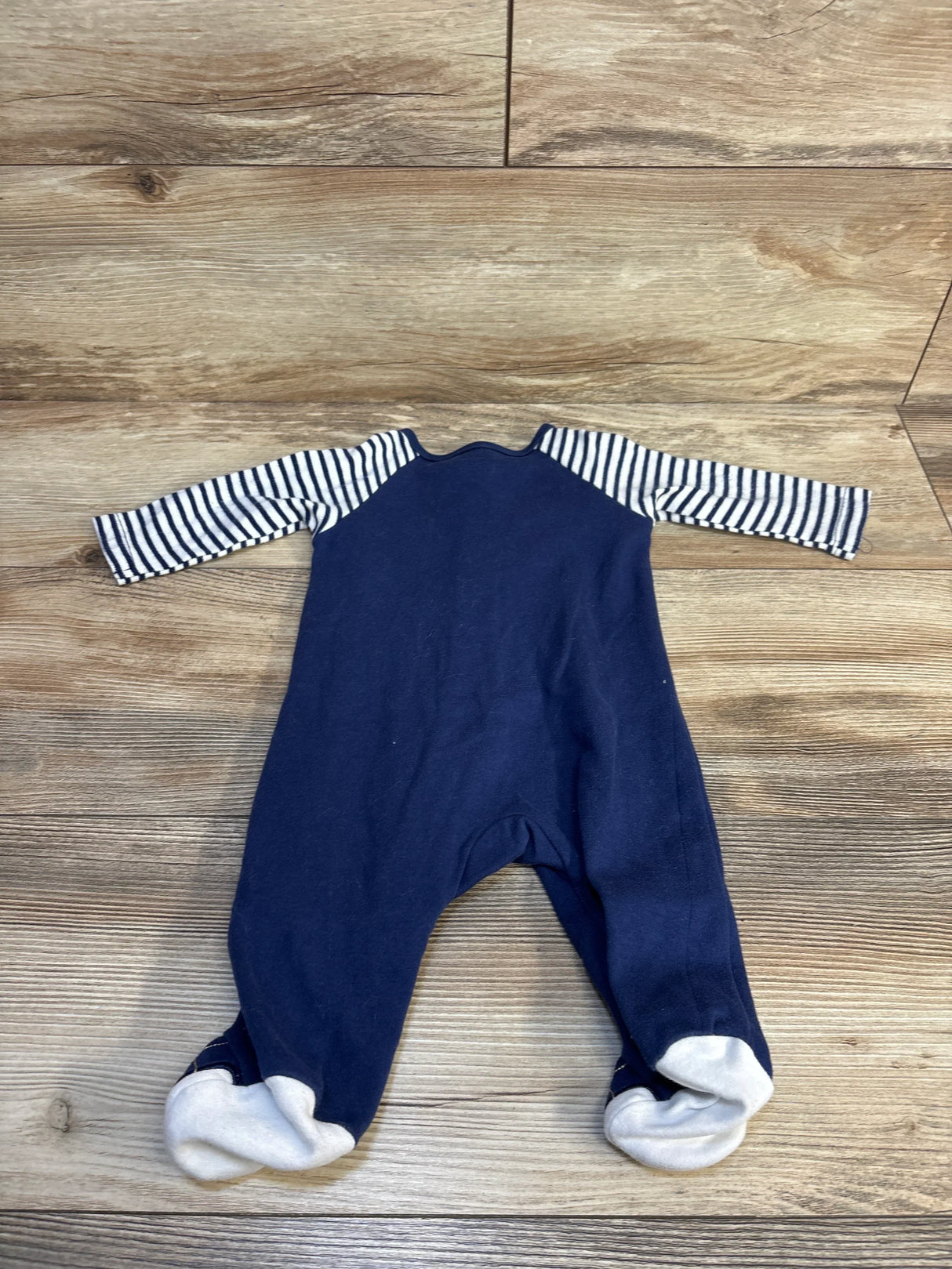 Navy blue baby footed onesie with striped raglan sleeves, perfect for infant sleepwear or everyday wear.