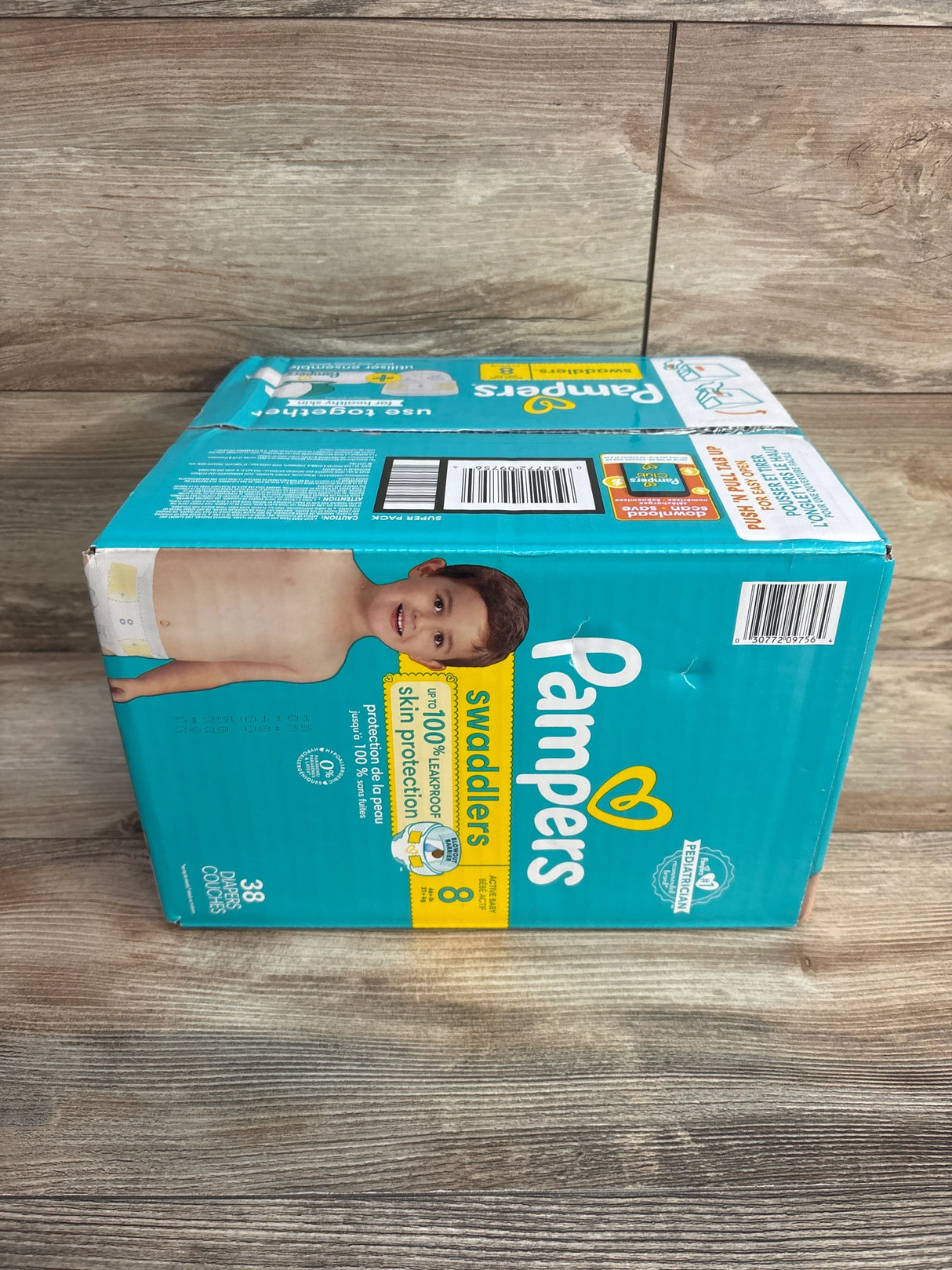 Box of Pampers Swaddlers size 8 diapers with child image on teal background, featuring skin protection and leakproof claims