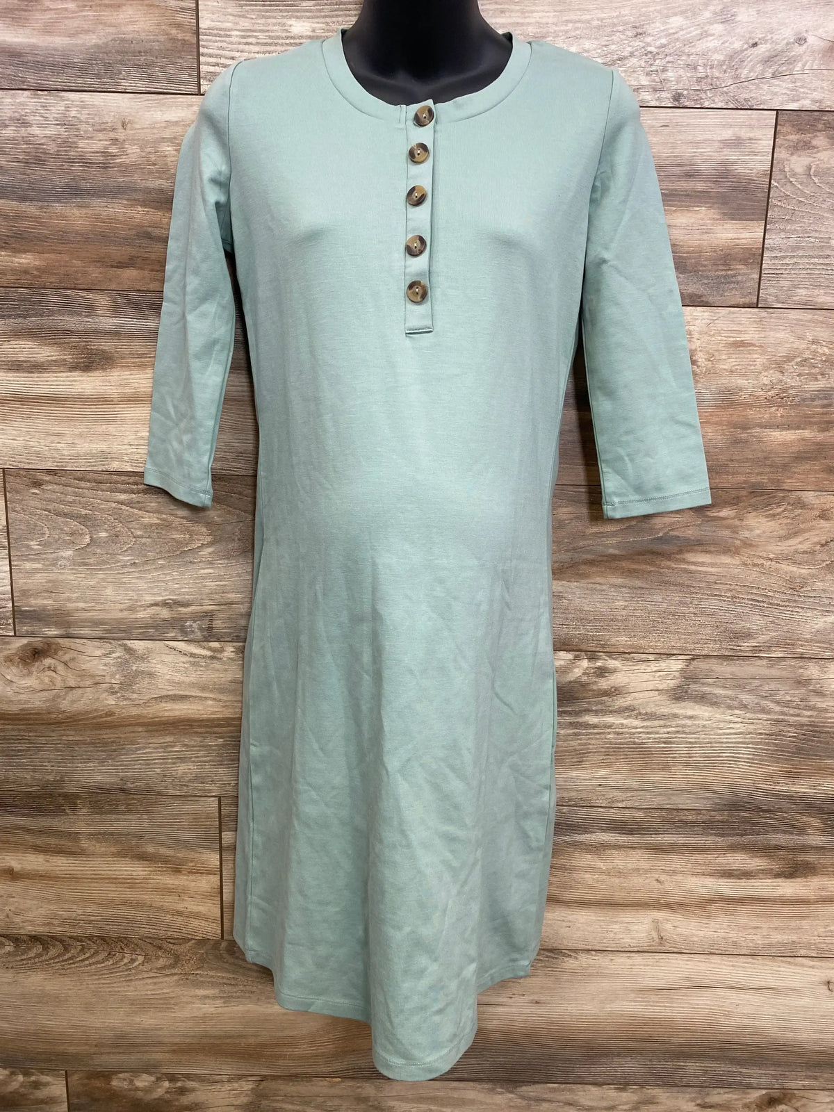 Front of Lou Lou Faux Henley maternity dress sage green on black mannequin with three-quarter sleeves and five-button placket