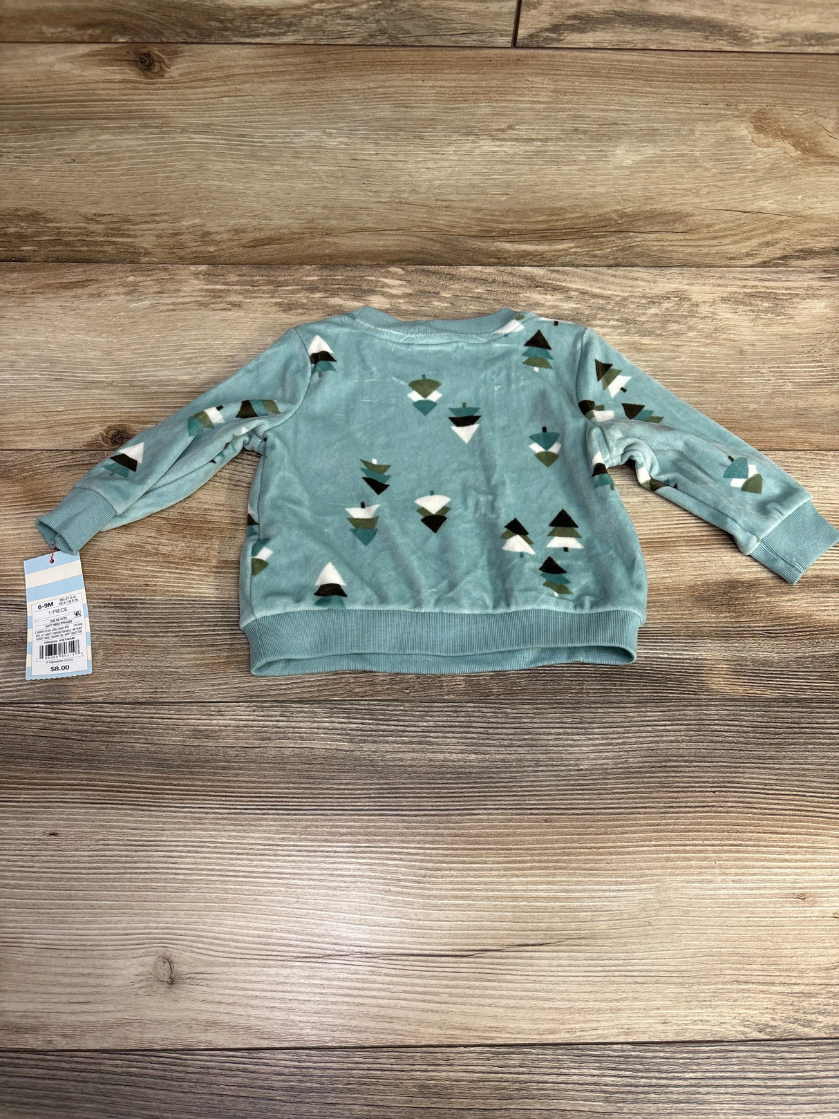 Blue baby sweatshirt with geometric tree print, long sleeves, displayed on wood floor