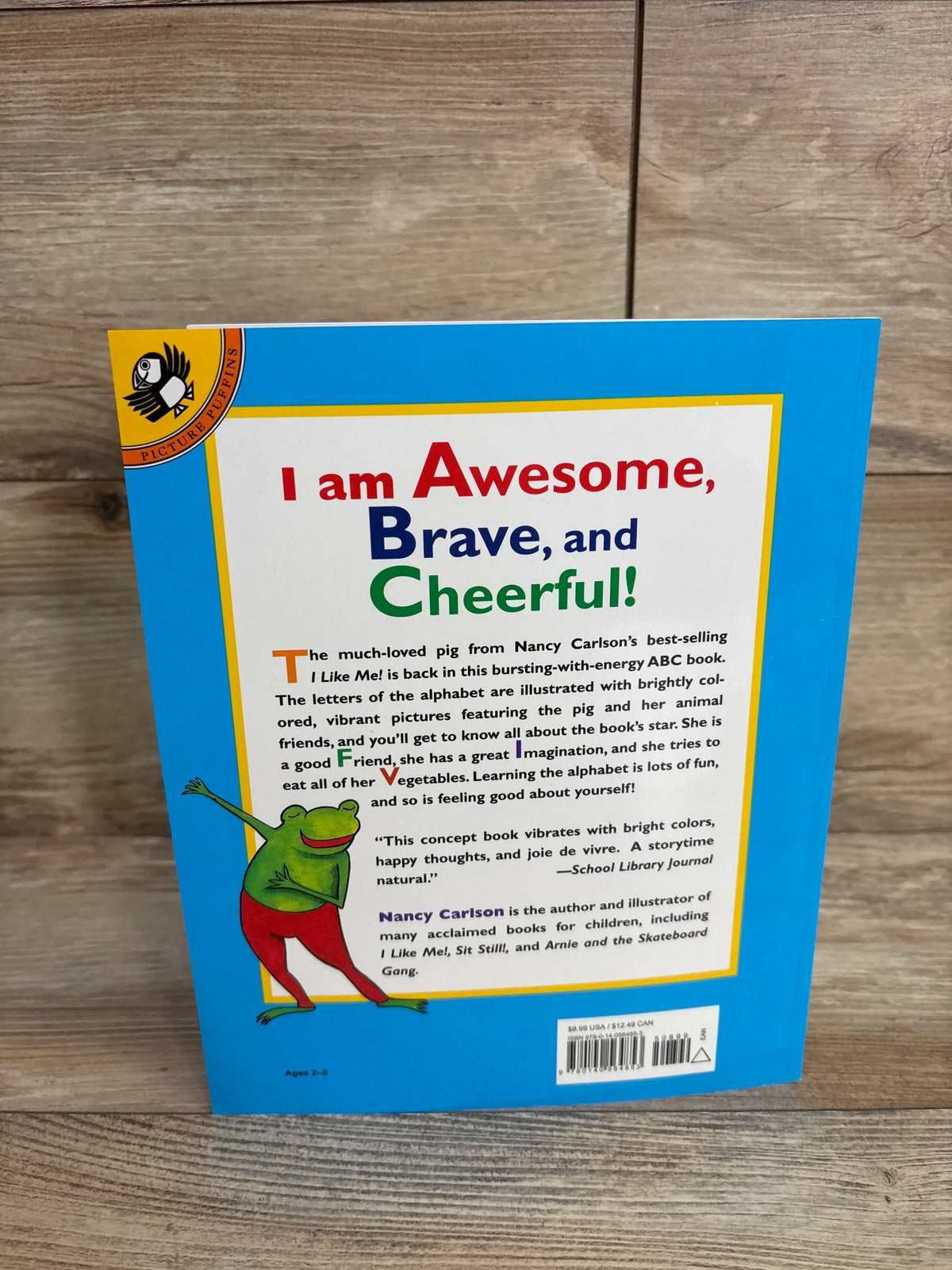 Back cover of ABC I Like Me! paperback showcasing headline I am Awesome, Brave, and Cheerful! with a green frog illustration and barcode on blue background
