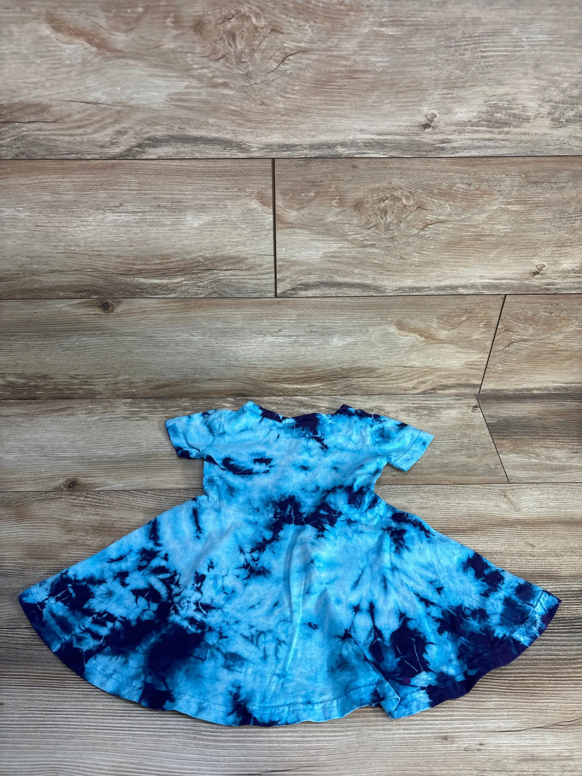 Front view of Dharma tie-dye heart dress in blue, size 2T, showcasing heart detail and flared skirt on wood floor