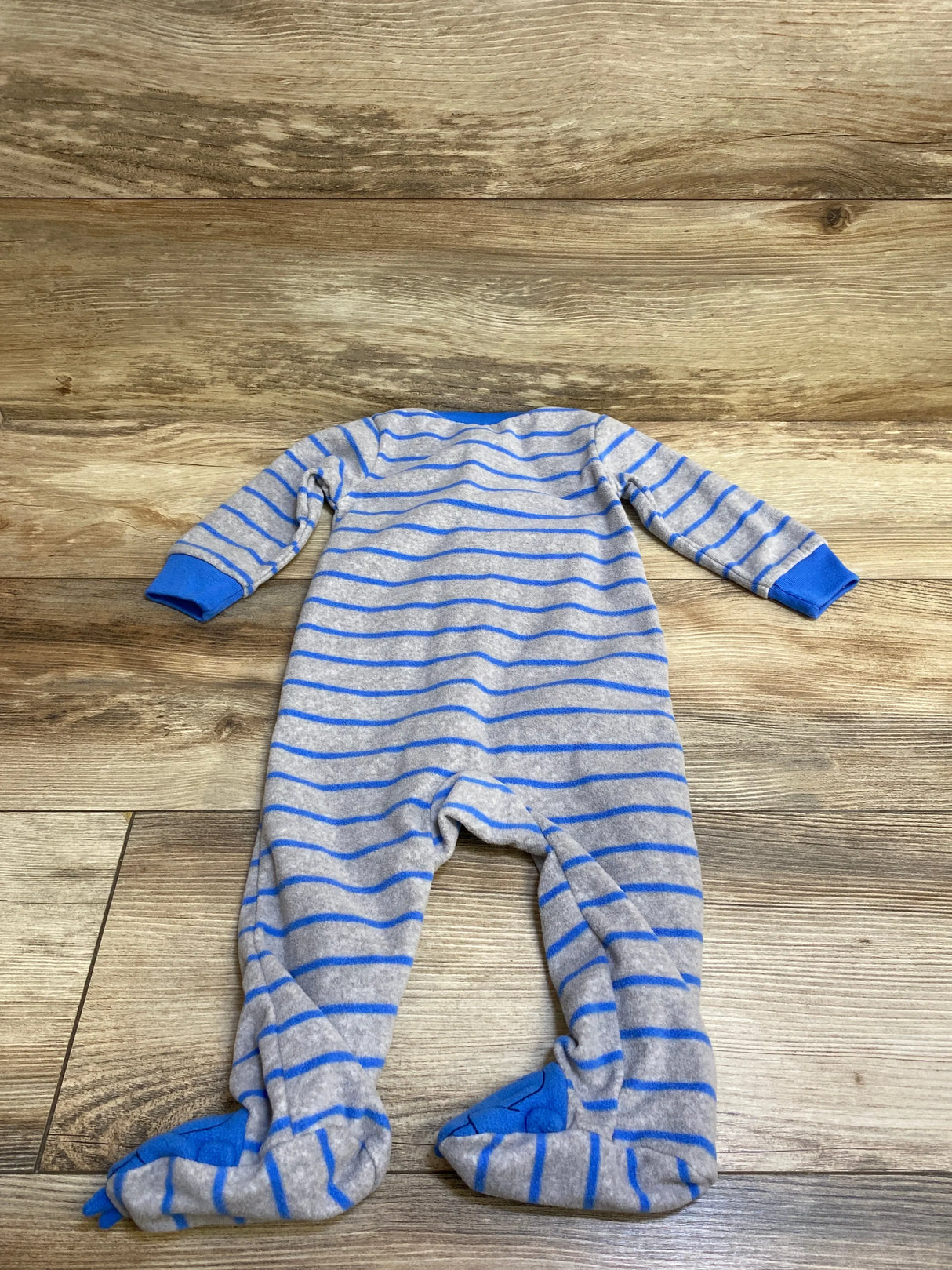 Gray and blue striped baby footed sleeper pajamas on wood background