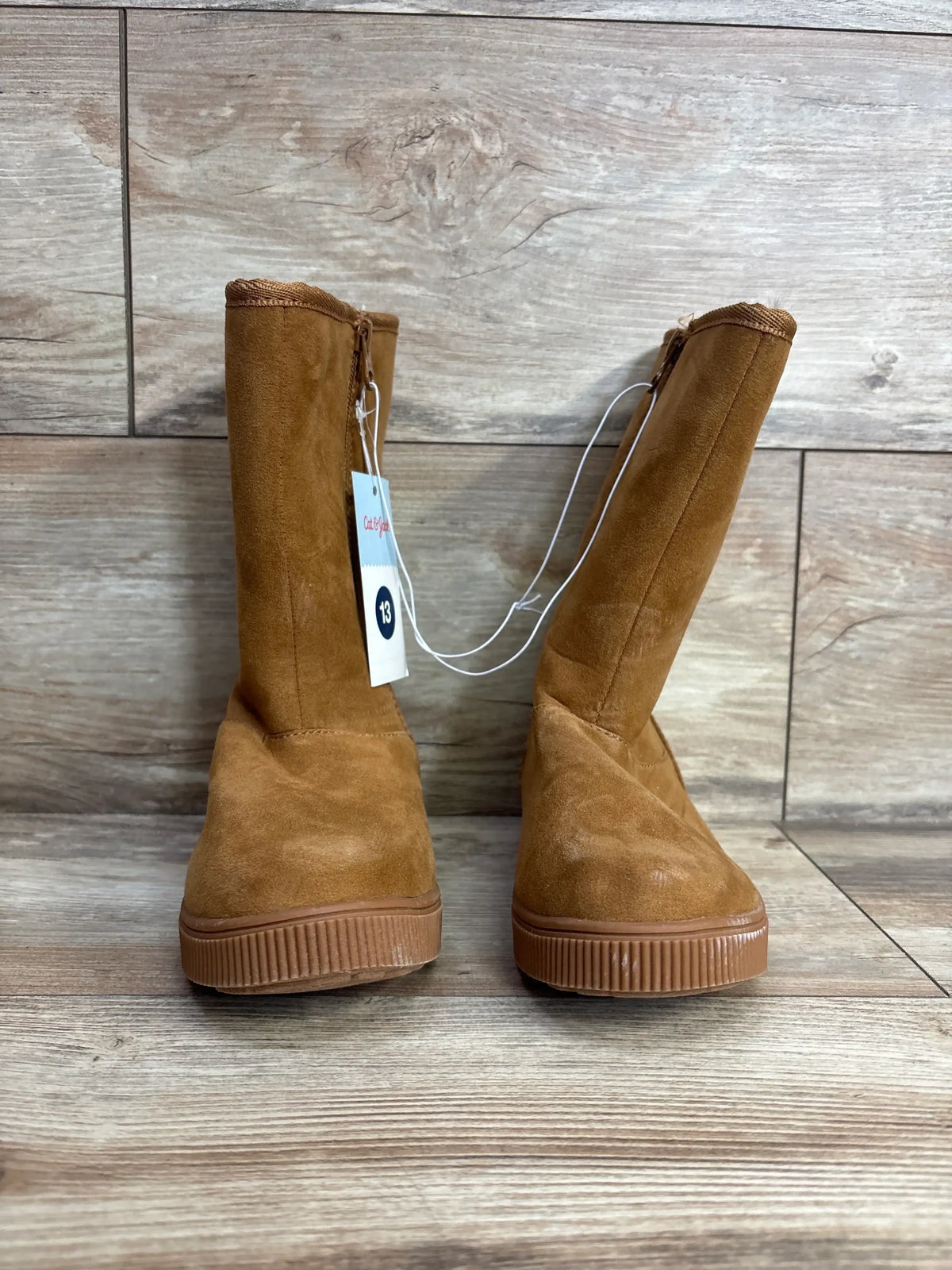 Brown suede kids boots with rubber soles and side zipper, size 13, on wood floor