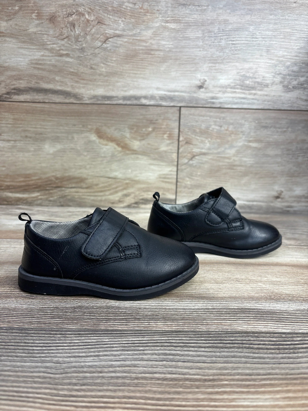 Three-quarter view of Wonder Nation Oxford toddler dress shoes size 7C in black leather with Velcro strap on wood floor