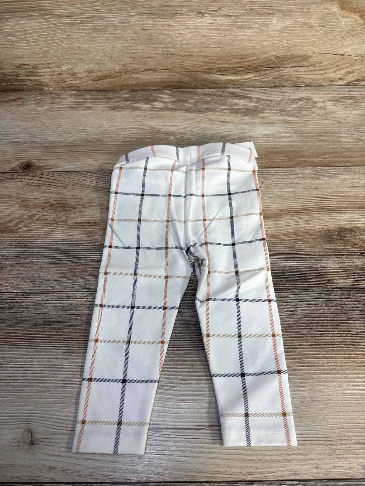 Front view of Janie & Jack Plait Button Ponte Pants showcasing preppy plaid and elasticized waist with a wood-grain background