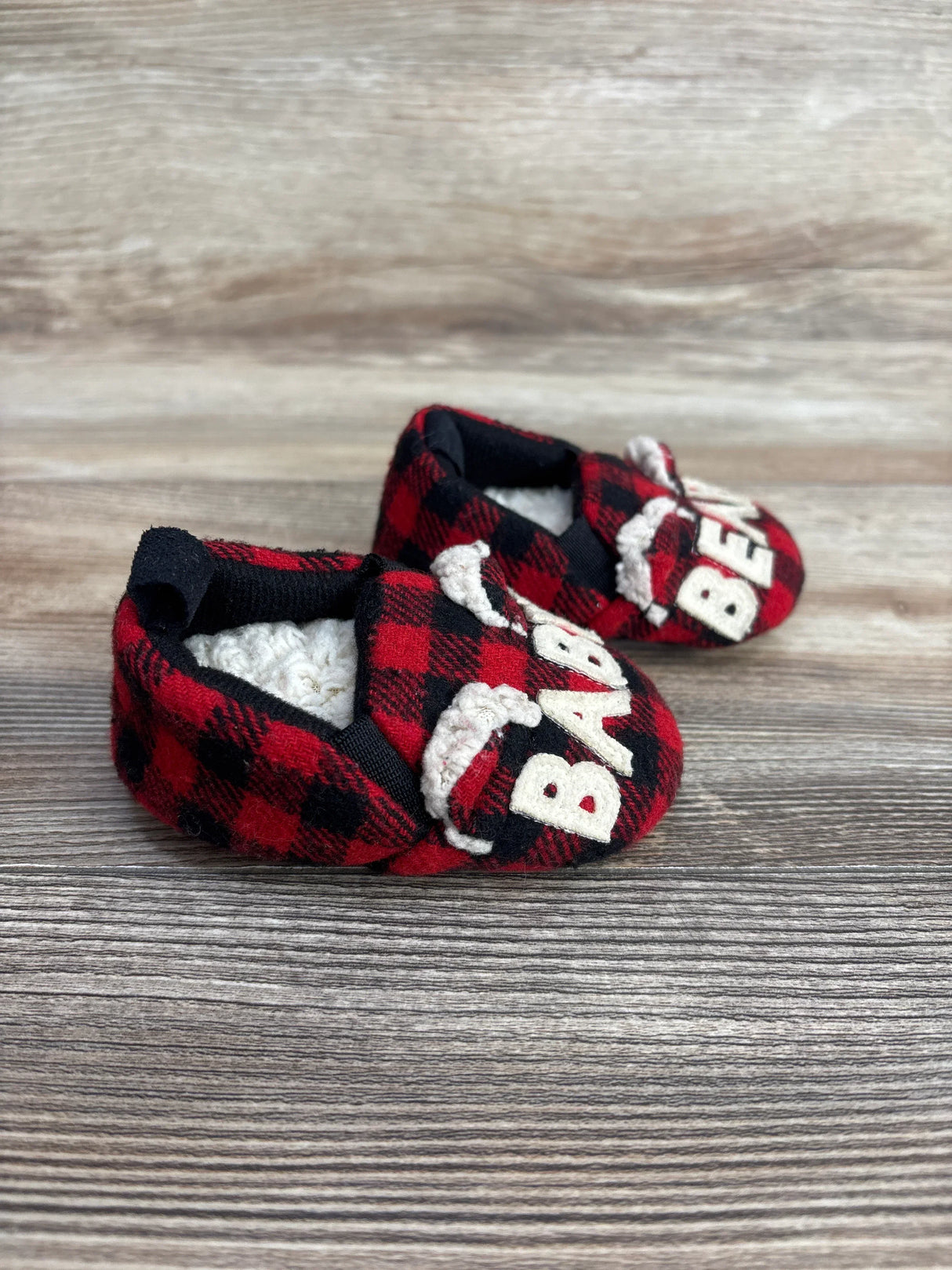 Front three-quarter view of Dearfoams Baby Bear slippers, red and black plaid with BABY BEAR embroidery and sherpa lining