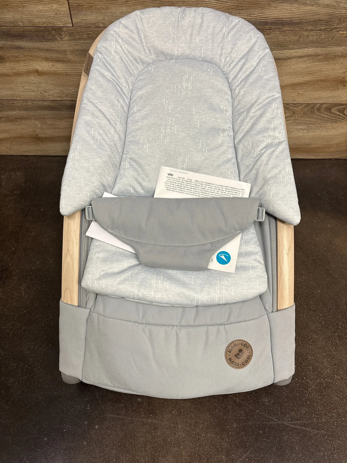 Top view of Maxi-Cosi Kori baby rocker showcasing padded classic slate seat and wooden side rails on dark floor