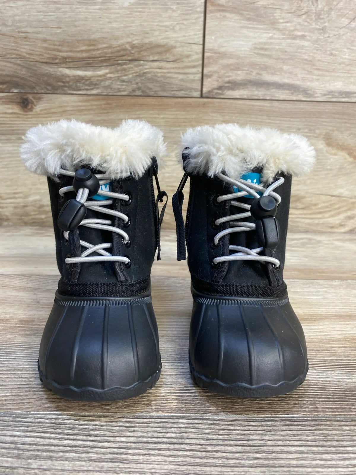 Black toddler winter boots with faux fur lining and rubber soles on wood floor