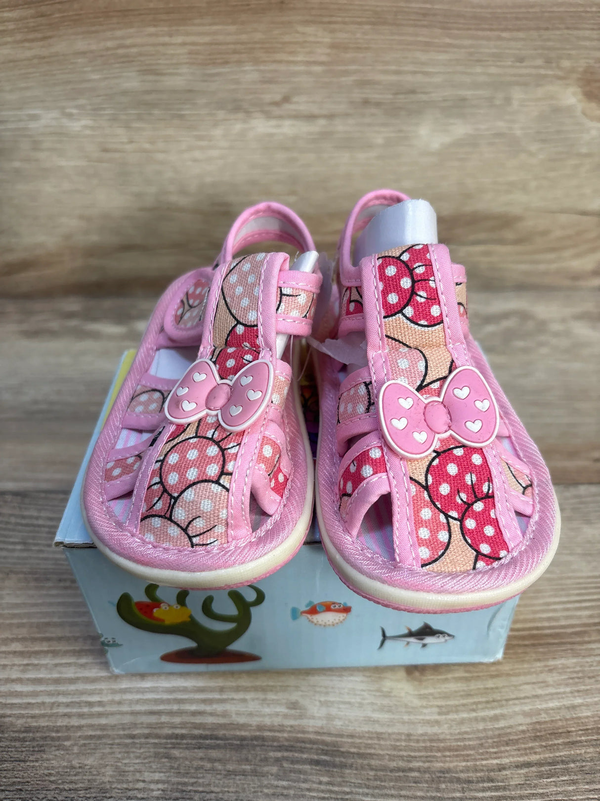 Front view of Papos Walk n' Squeak toddler sandals, pink size 6/7C, with polka-dot bow embellishments and open toes