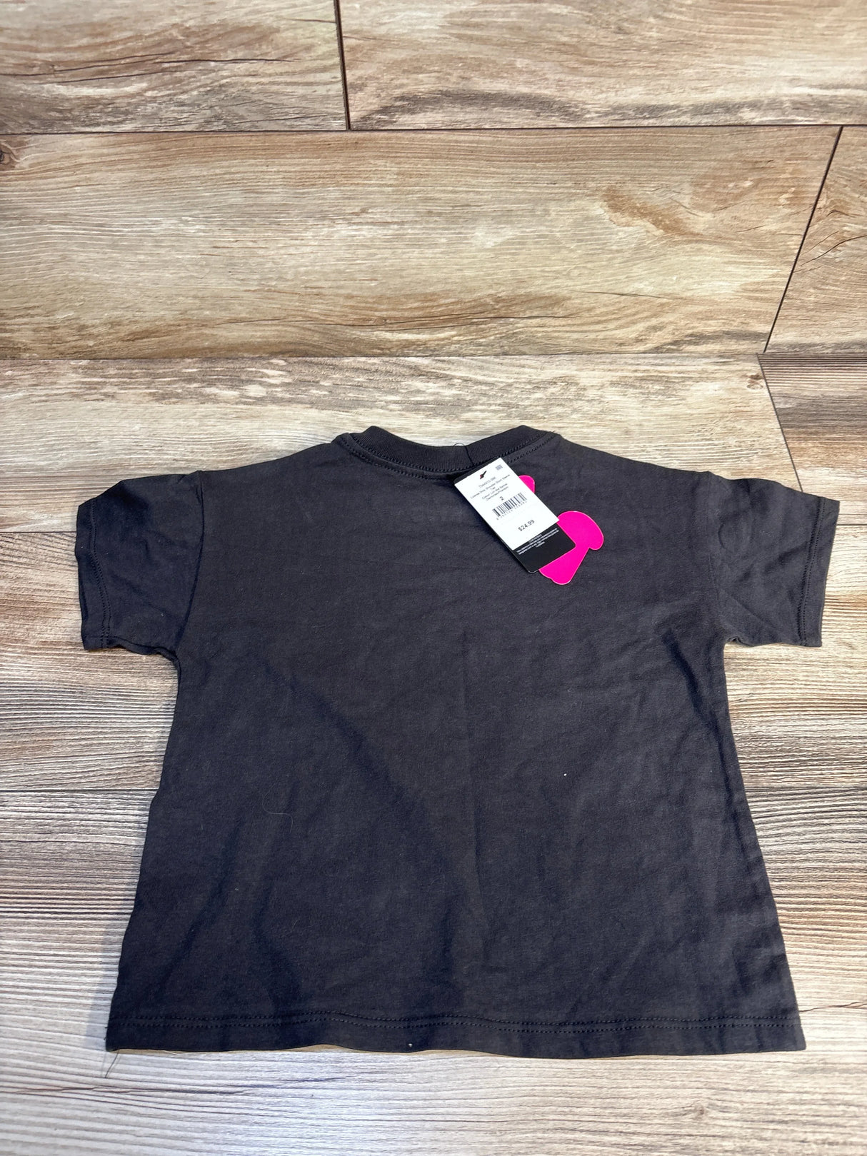Back view of NEW Cotton On Kids Barbie short sleeve shirt sz 2T showcasing dark grey cotton tee with retail hangtag on wood plank floor