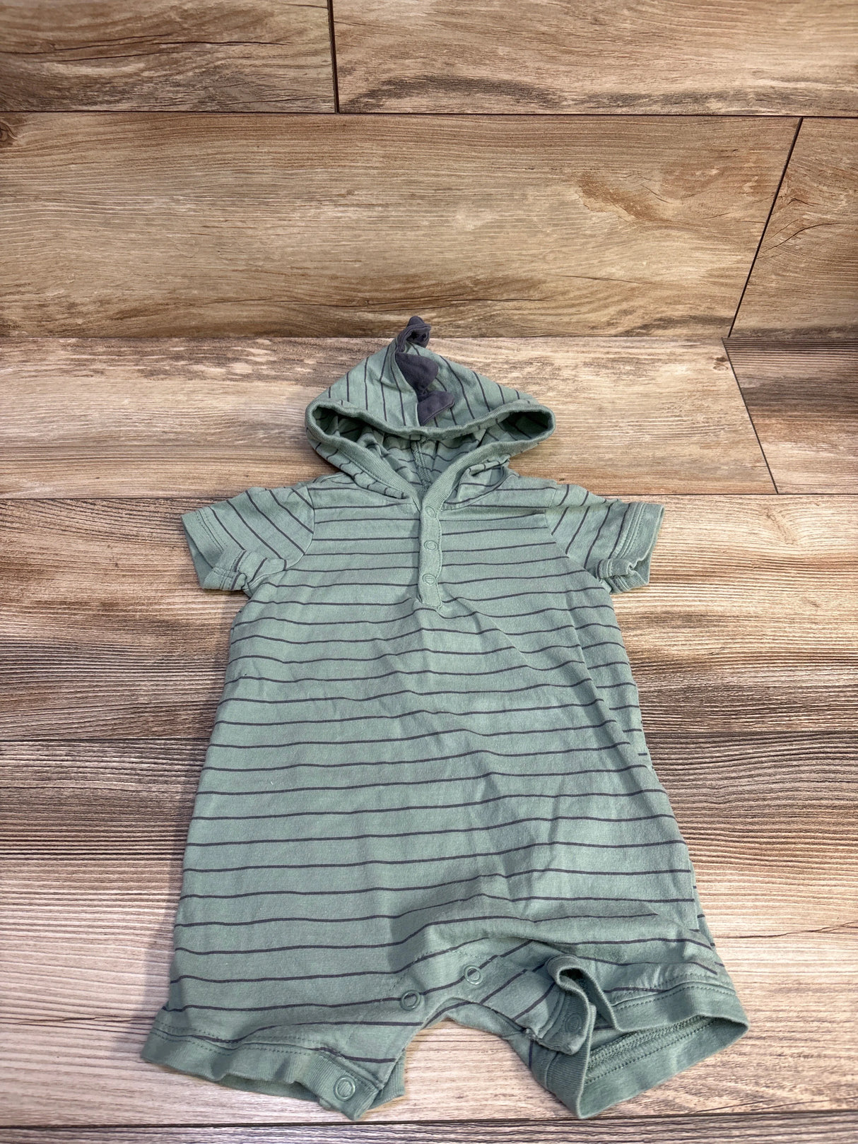 Top view of Carter’s hooded henley shortie romper in green size 9m with horizontal stripes and snap closures on a wood floor