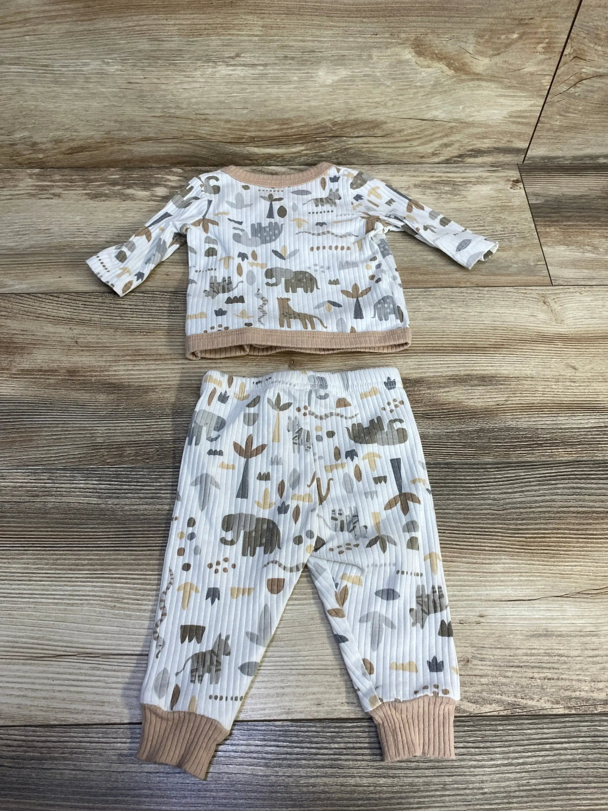 Flat lay of DreamGro 2-piece ribbed kimono pajama set in white with gray and tan animal print and tan cuffs on wood background