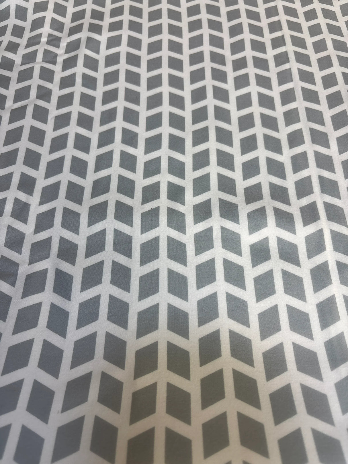 Gray and white geometric chevron pattern on soft fabric, nursery bedding textile