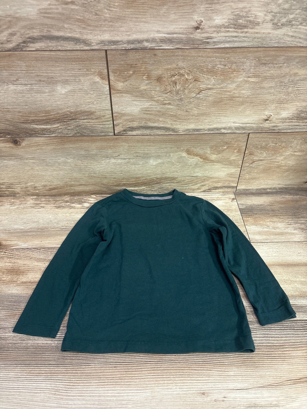 Dark green long sleeve toddler shirt by Me n Mommy To Be on a wooden background