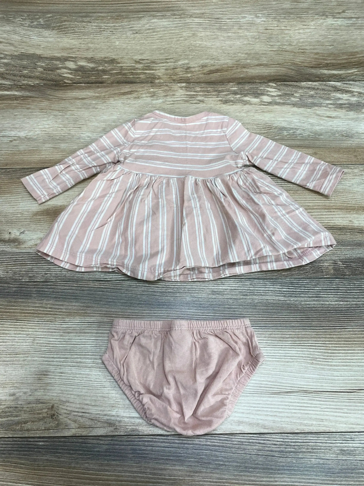 Flat lay of pink striped baby dress and bloomers, size 3 months, with gathered skirt and elastic waist on wood background