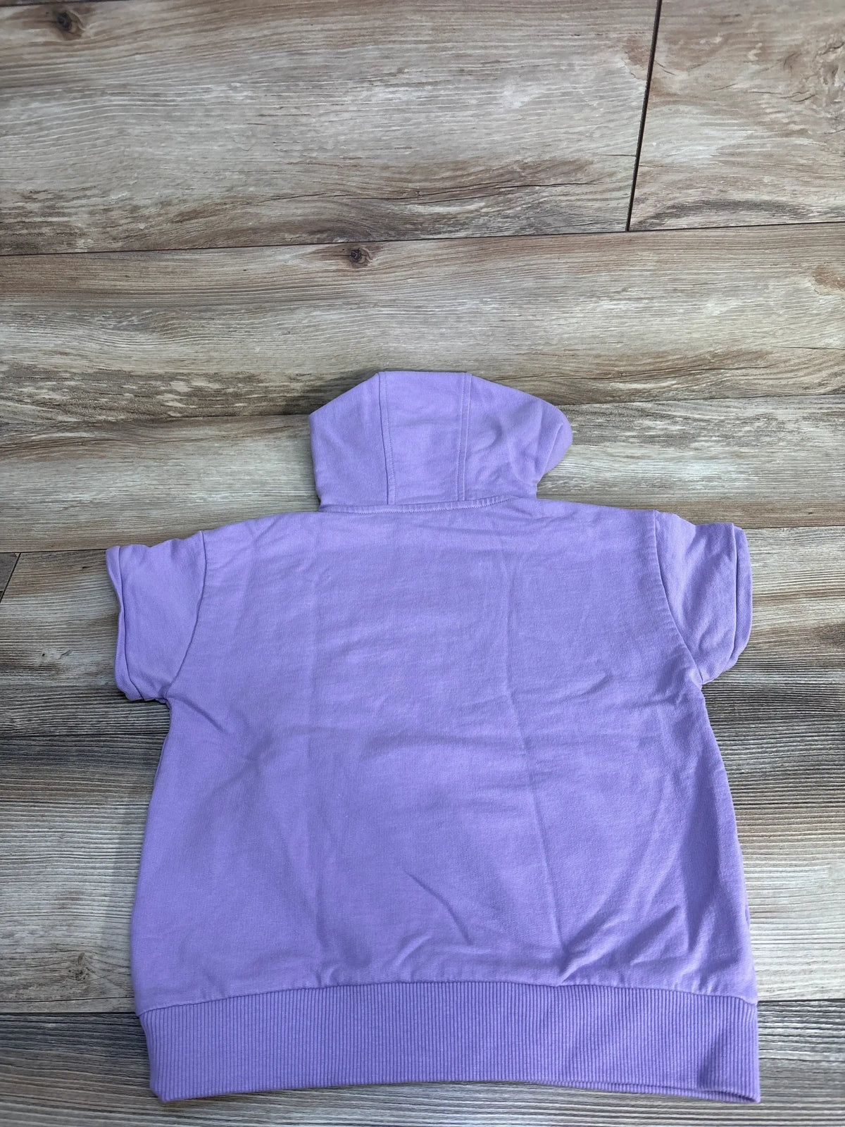Back view of a lavender short sleeve hoodie on wood floor