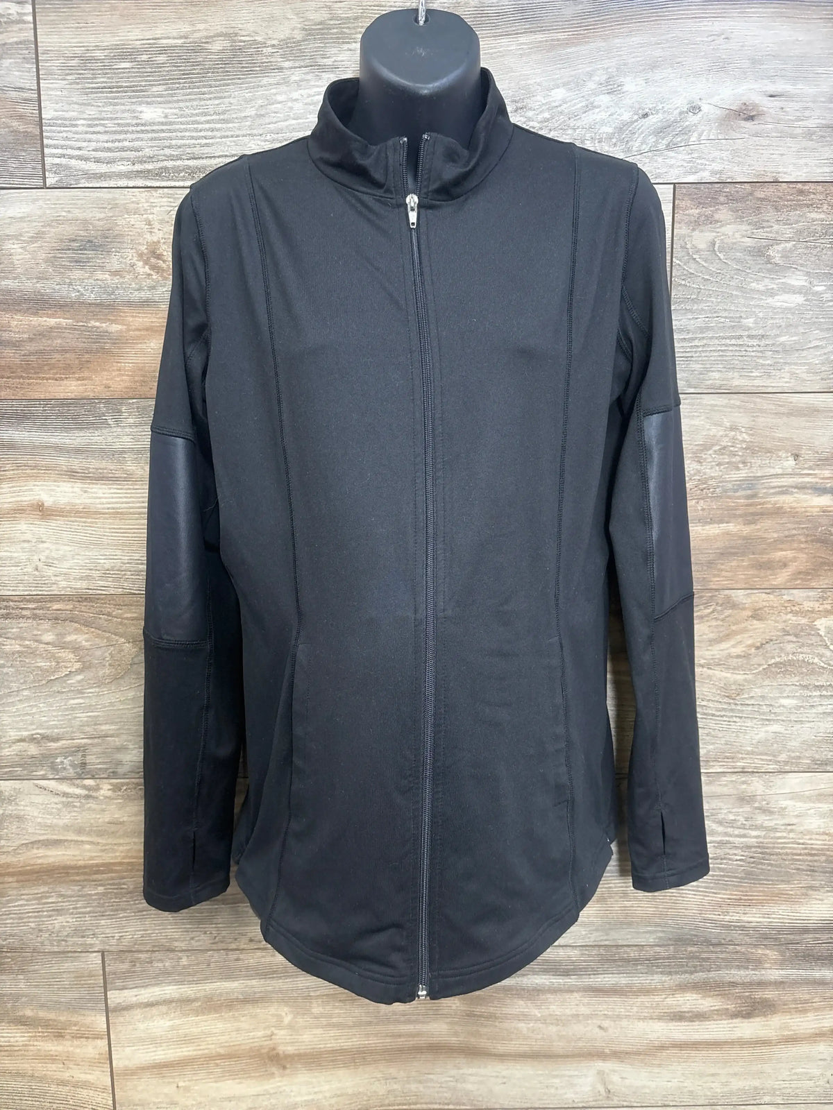 Front view of black Isabel maternity side zip jacket with full-zip front and long sleeves against a wood background